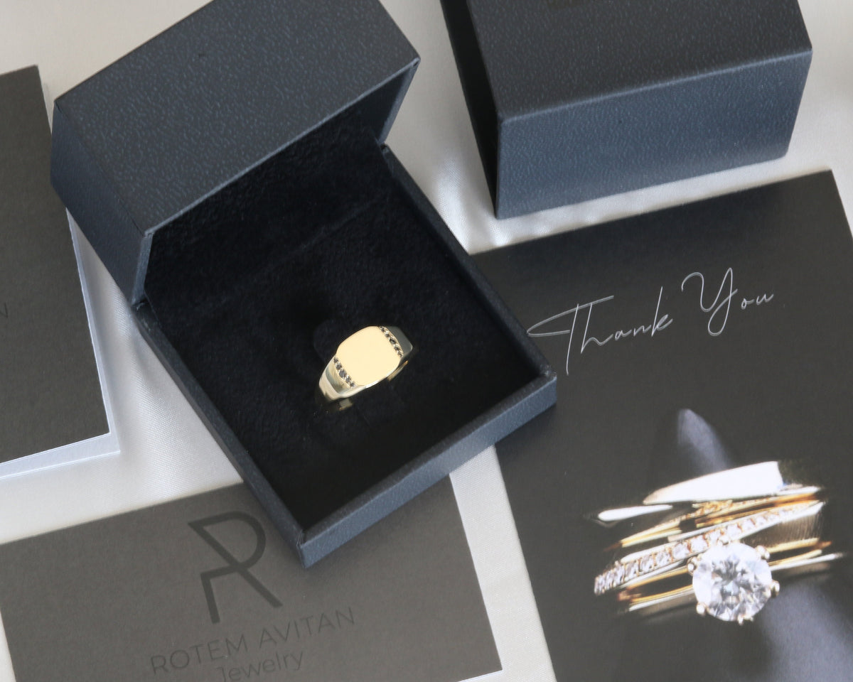 Men's yellow gold signet ring in a jewelry box with packaging