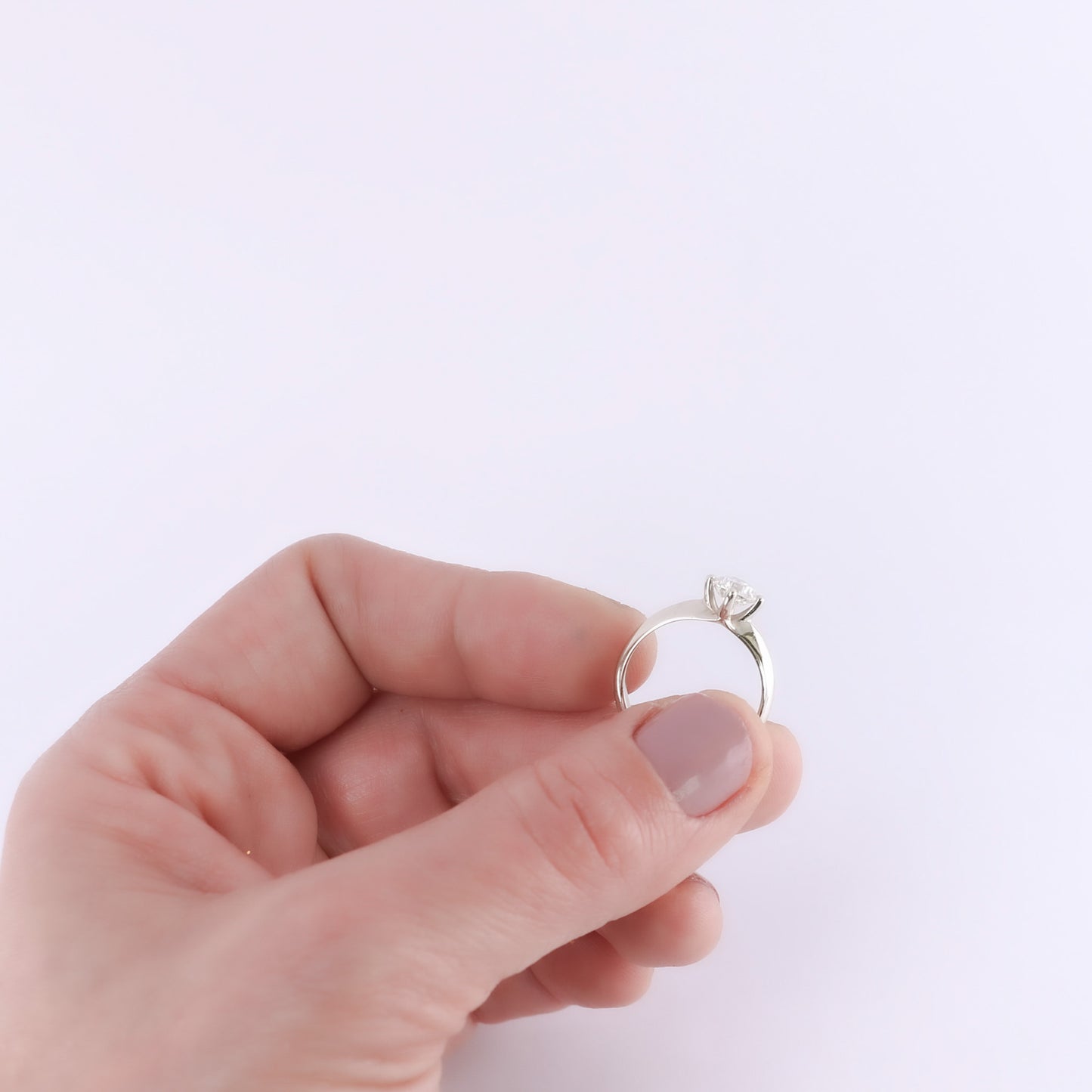 modern white gold solitaire showcased in womens hand