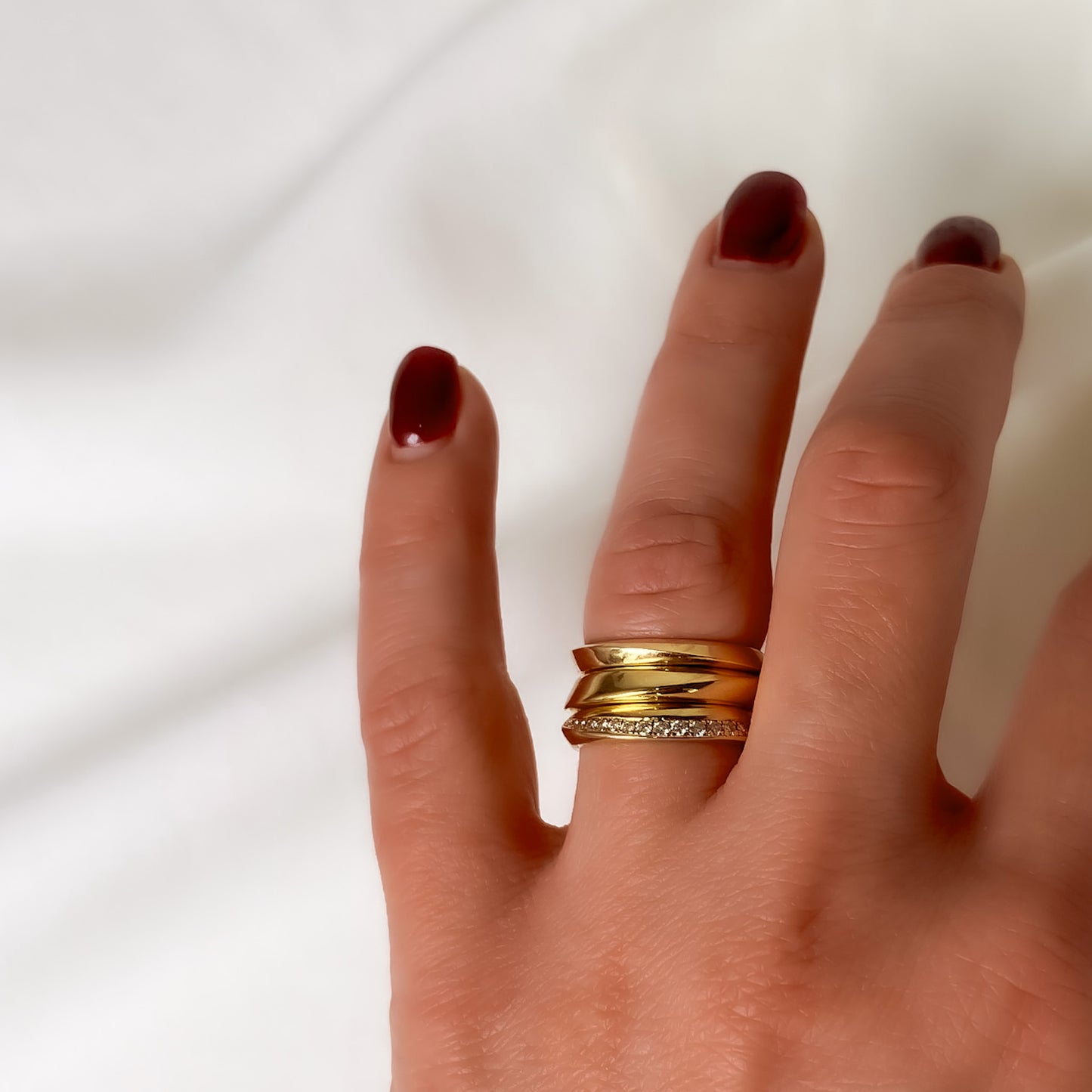 three gold rings stacked together on hand