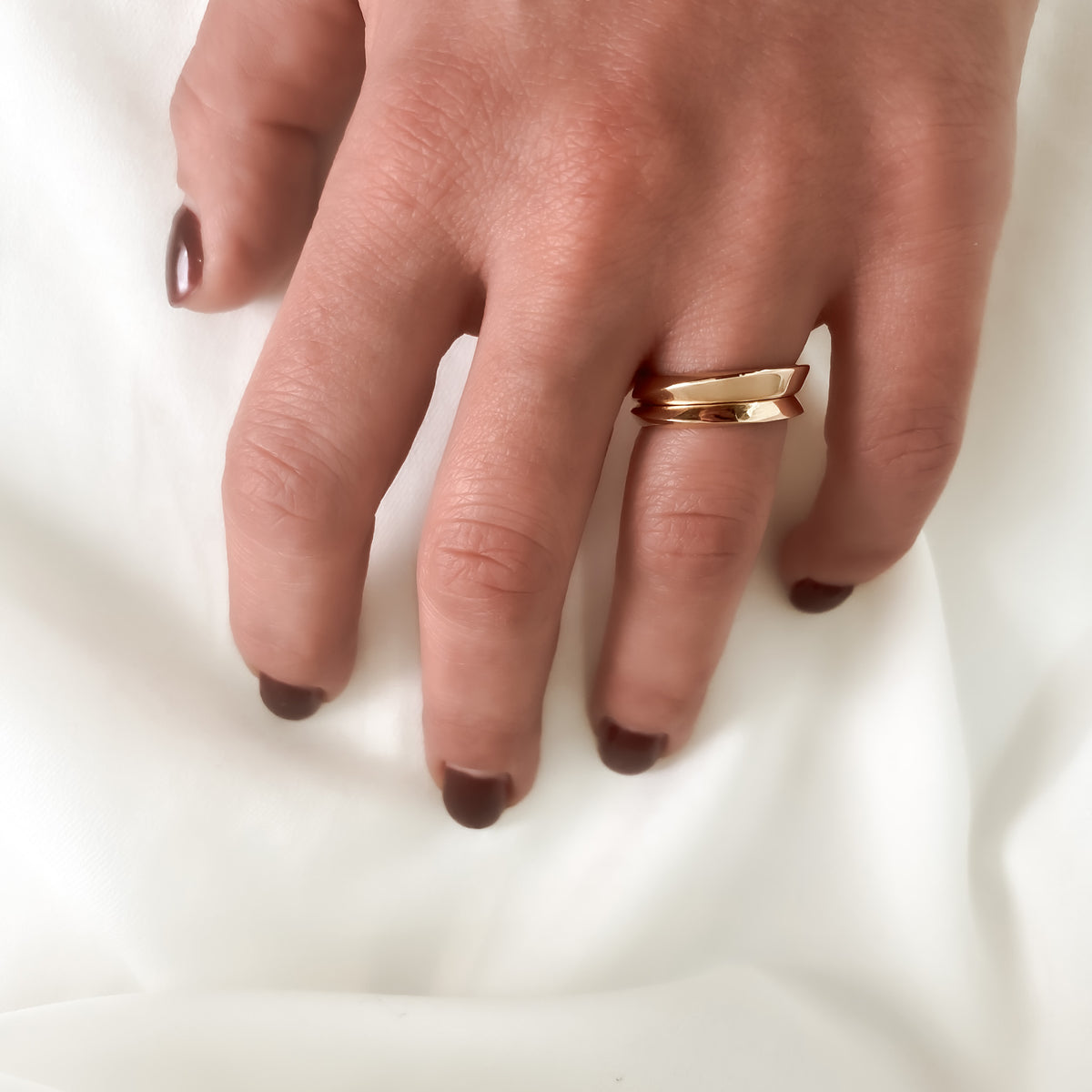 Two twisted gold wedding bands, 2.7 mm and 3.8 mm, stacked on the finger