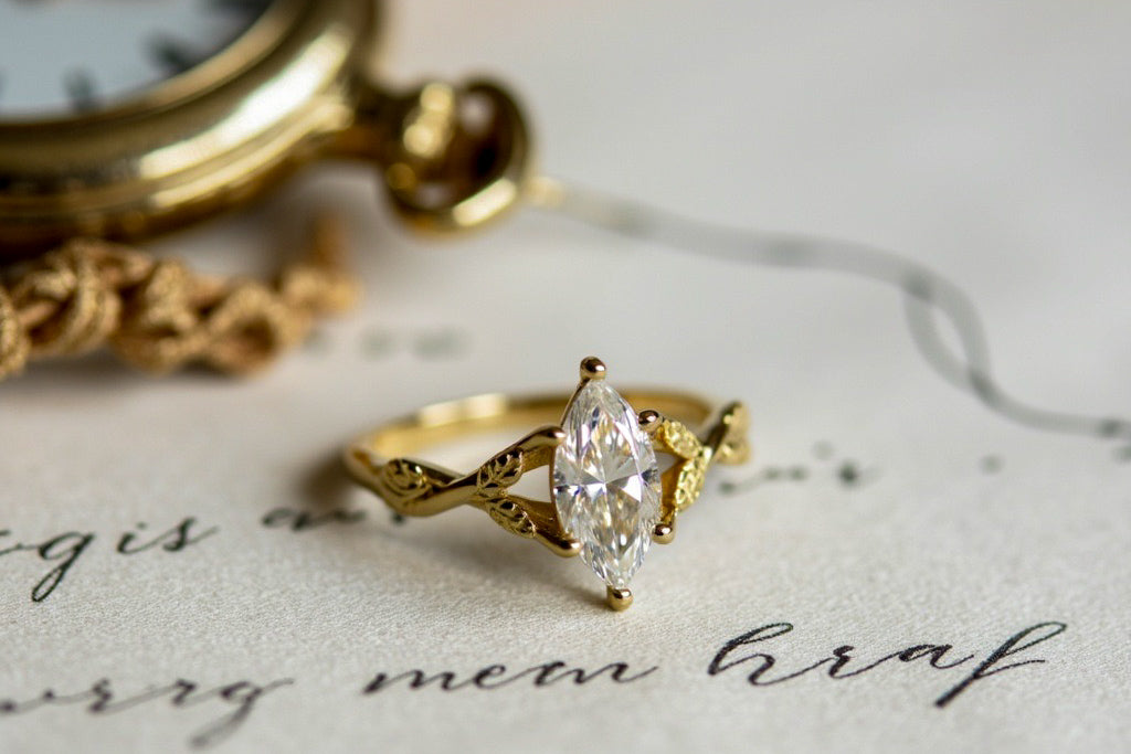 Close-up of a marquise-cut diamond gold ring resting on a handwritten note with a vintage pocket watch in the background — elegant fine jewelry photo symbolizing timeless care and craftsmanship.