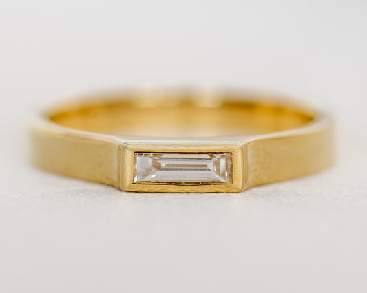 Front view of 14K gold baguette diamond ring with full bezel setting