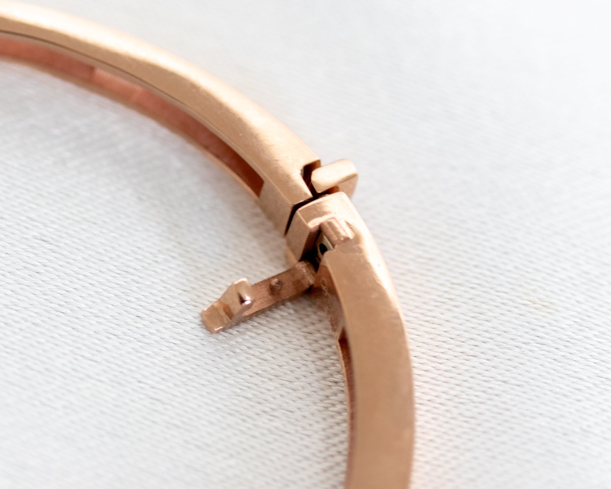 Detailed view of hinged clasp on 14K gold diamond bangle