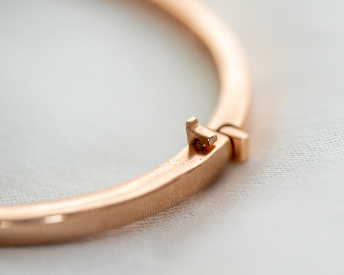 Close-up of 14K gold bangle clasp mechanism