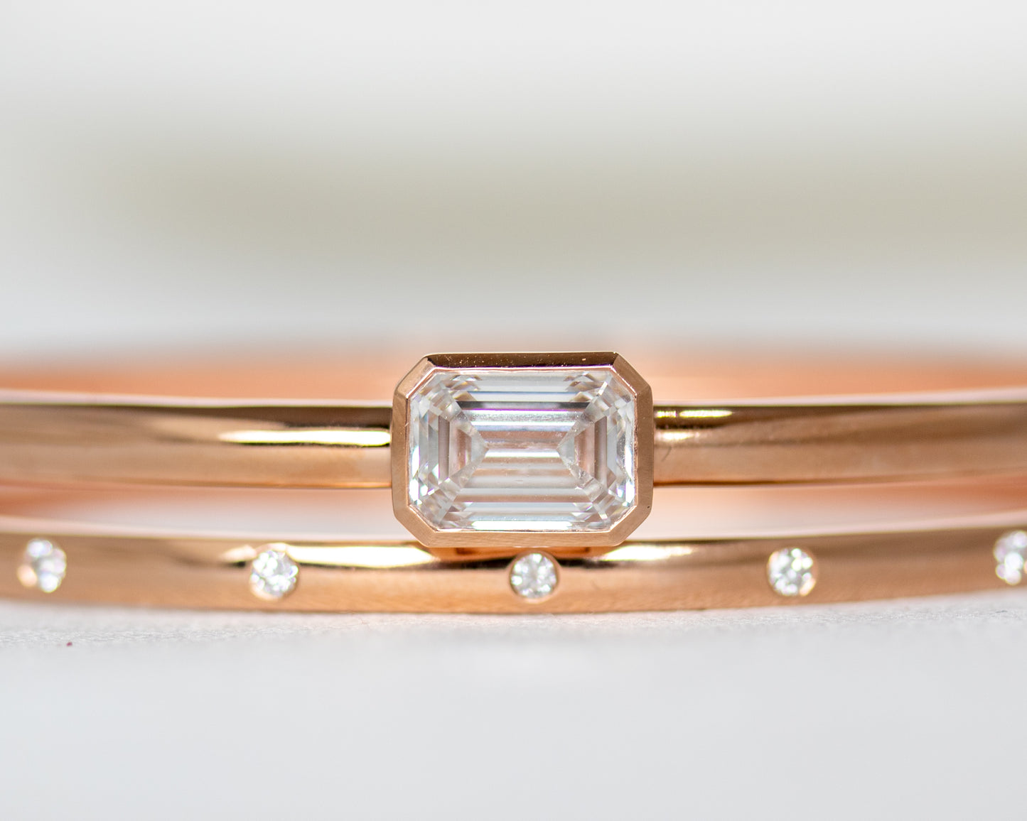 Close-up of emerald cut lab-grown diamond in 14K gold full bezel setting