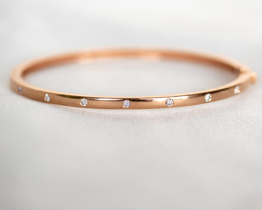 14K gold bangle with seven flush-set round diamonds, front view