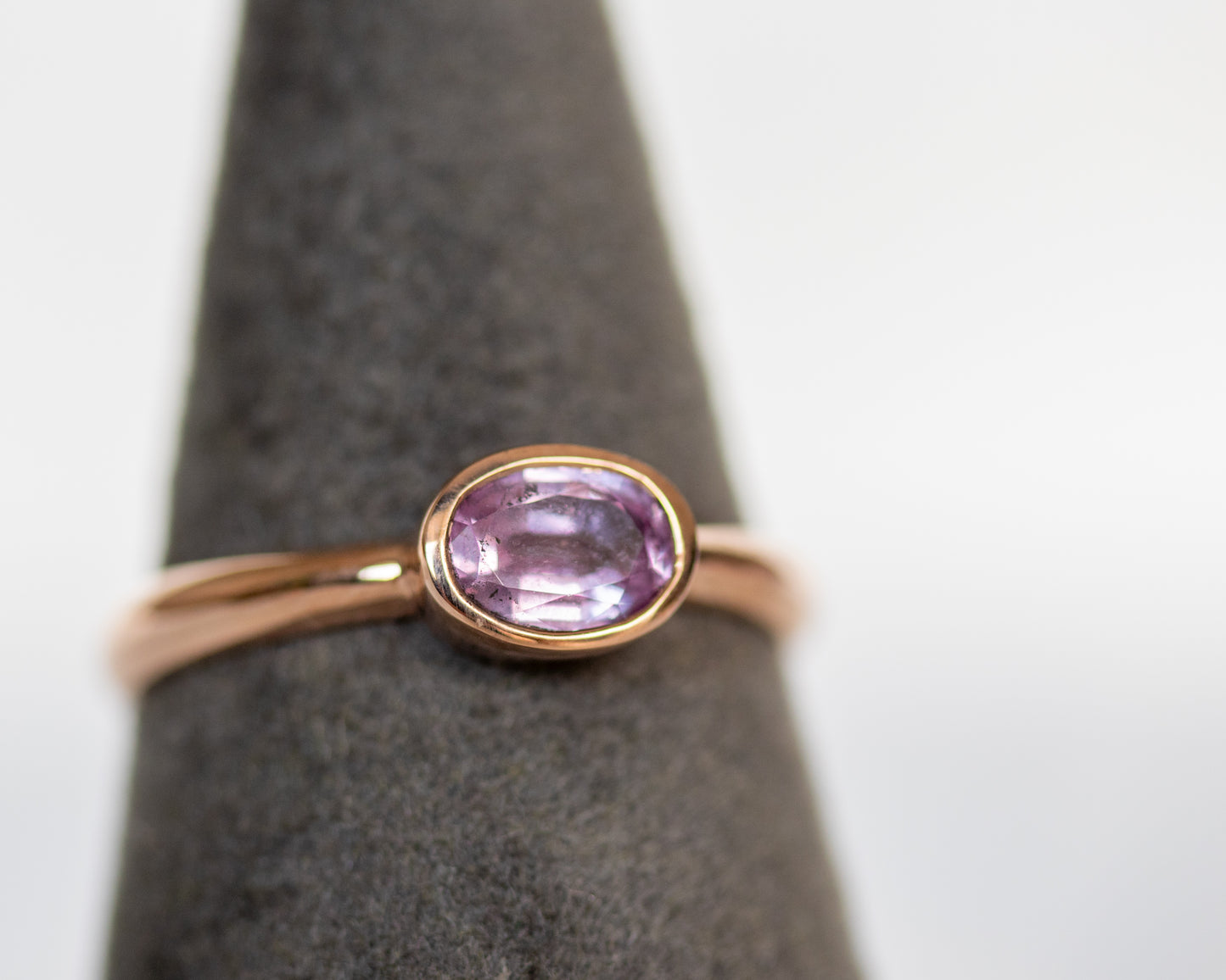 14K rose gold oval pink sapphire solitaire ring on ring stand