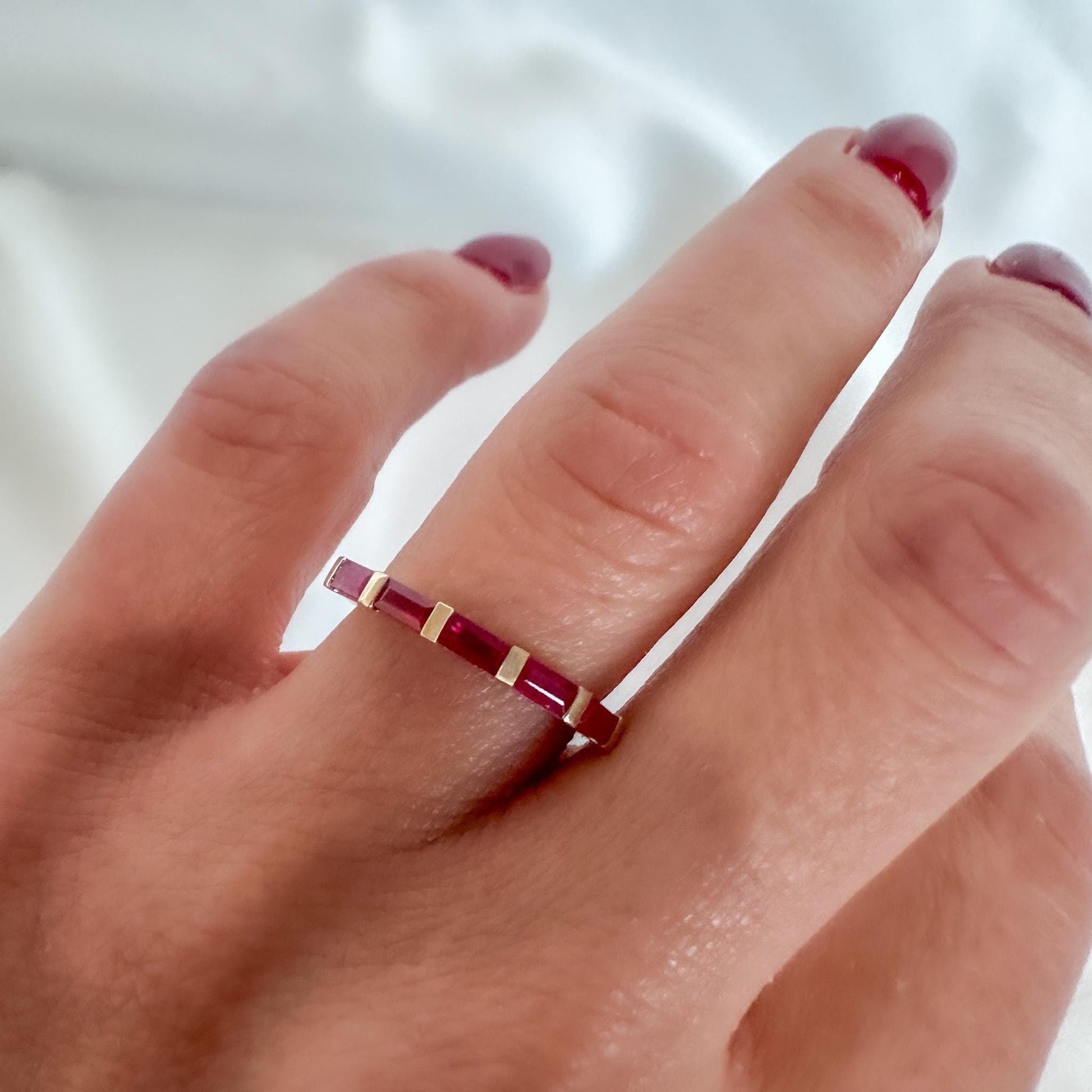 14K gold ruby baguette ring on hand — minimalist fine jewelry with geometric design
