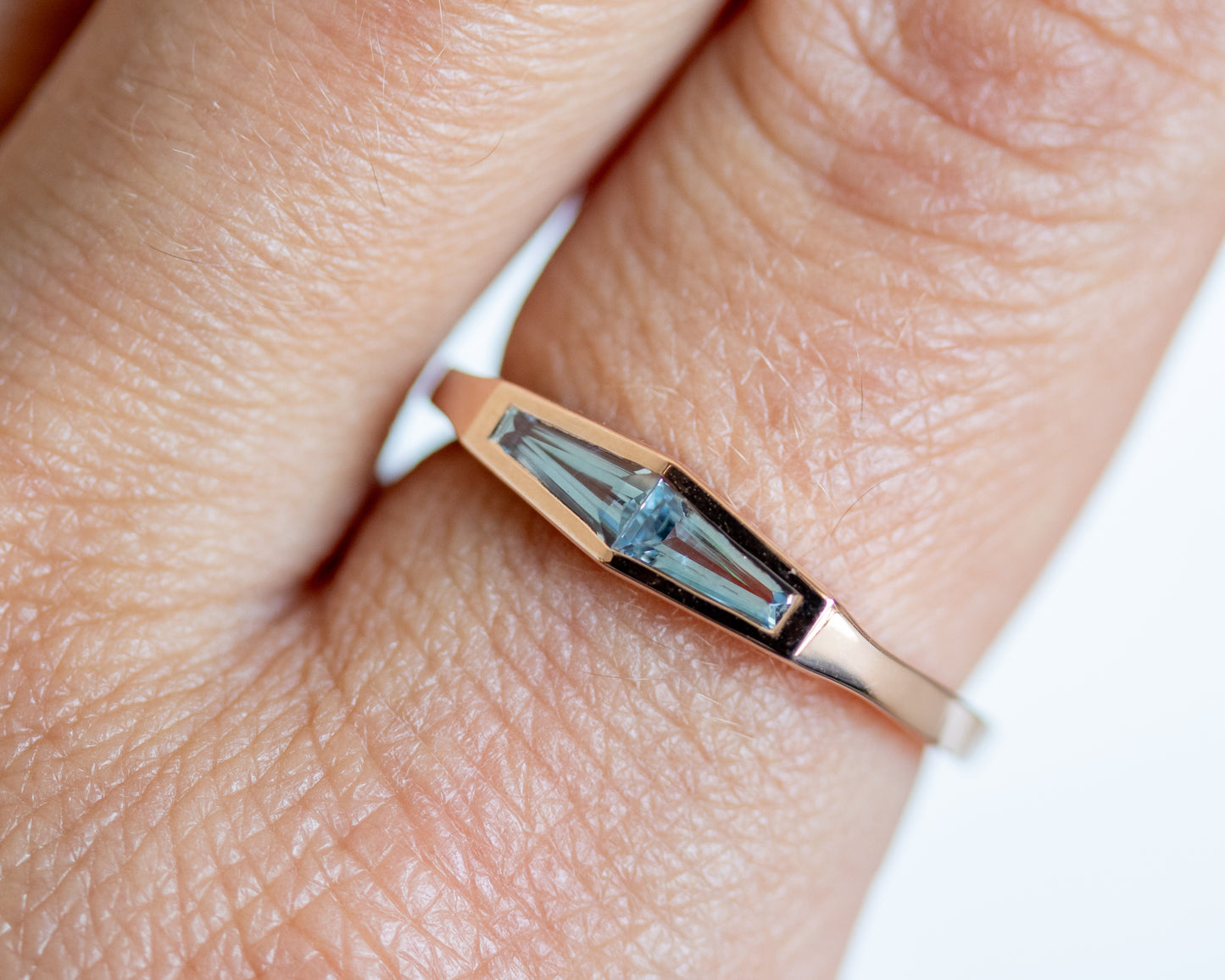 Natural aquamarine two-stone ring in 14K rose gold, close-up on the finger