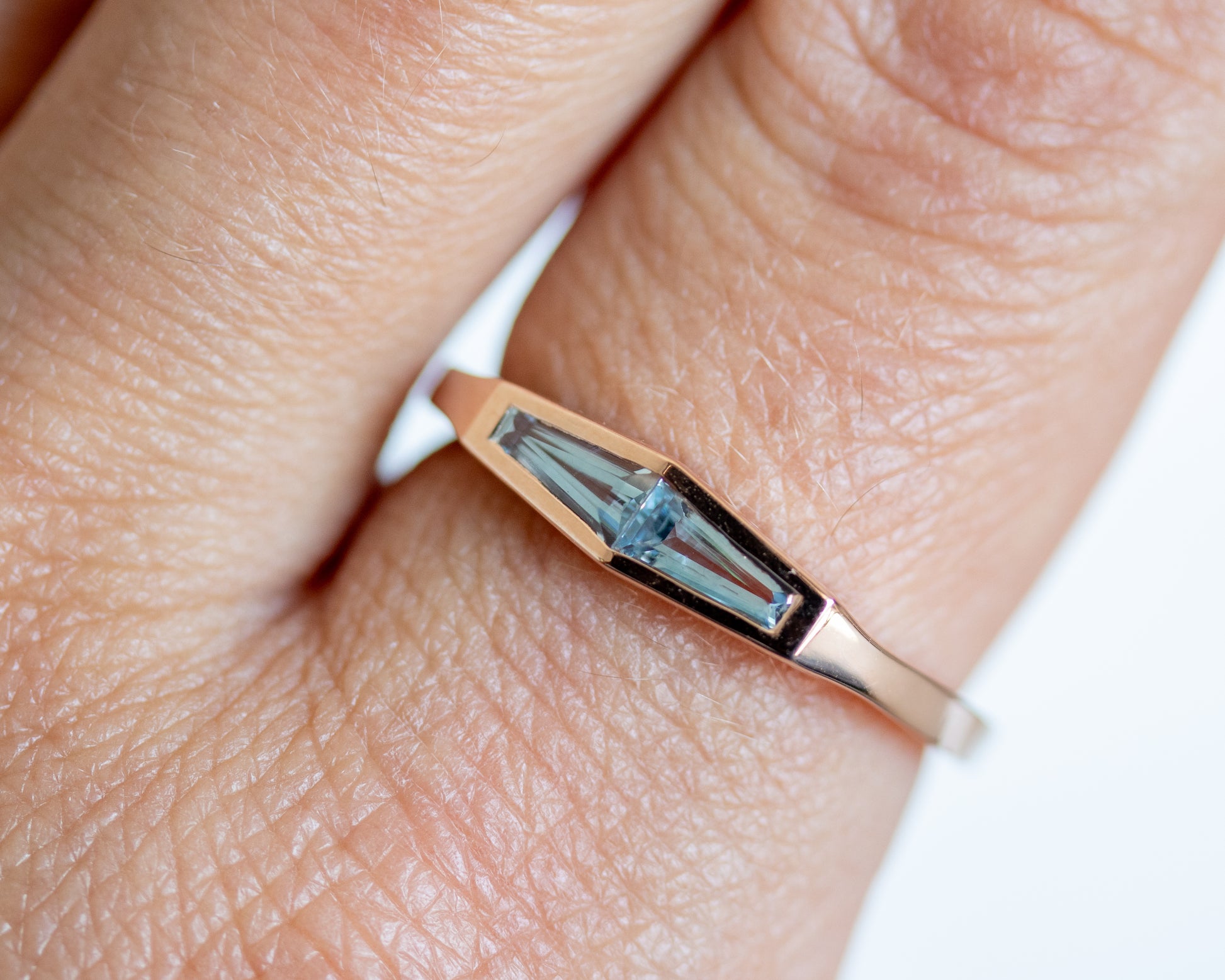 Natural aquamarine two-stone ring in 14K rose gold, close-up on the finger