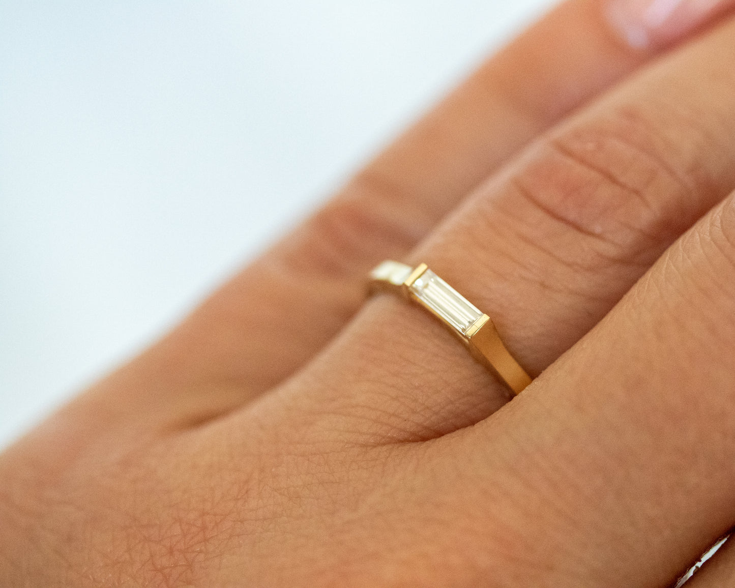 Close-up of a baguette diamond ring on the finger