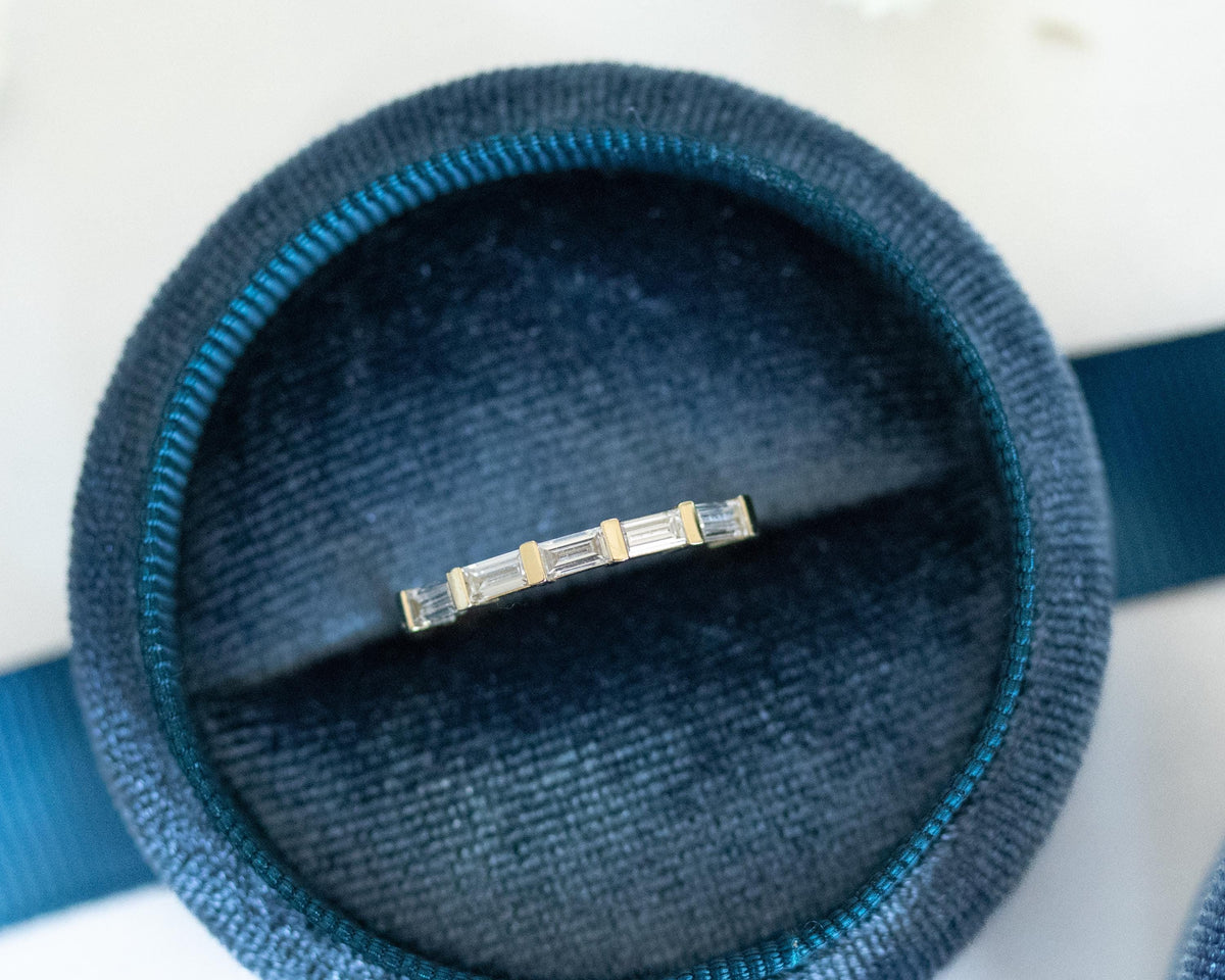 Bar-set baguette diamond ring in 14K yellow gold, side angle in a blue velvet ring box