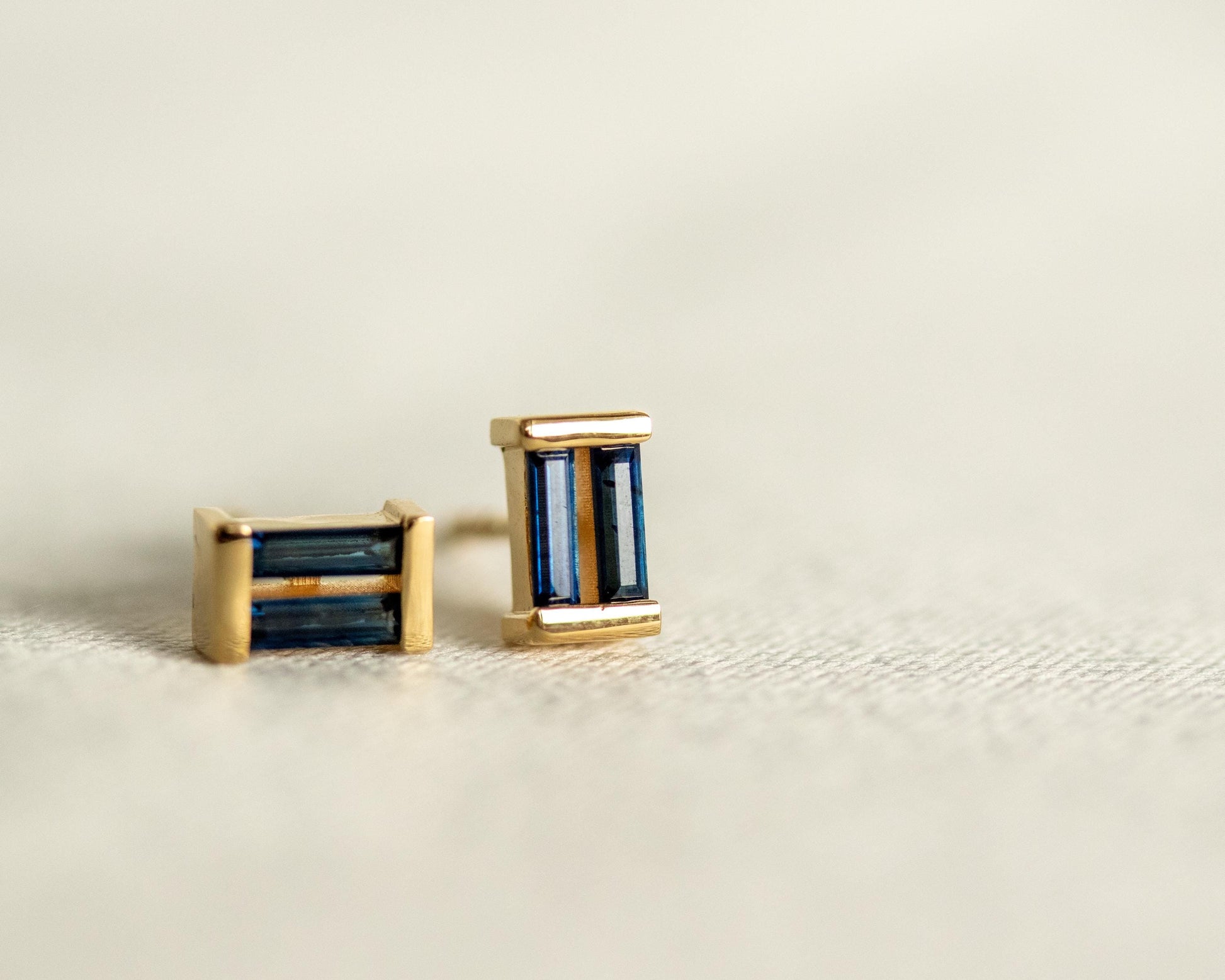 Close-up of blue sapphire baguette studs set in gold