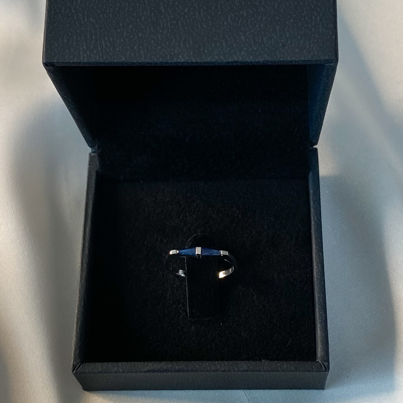 A 14K white gold ring with two natural blue tapered baguette cut sapphires in black velvet box