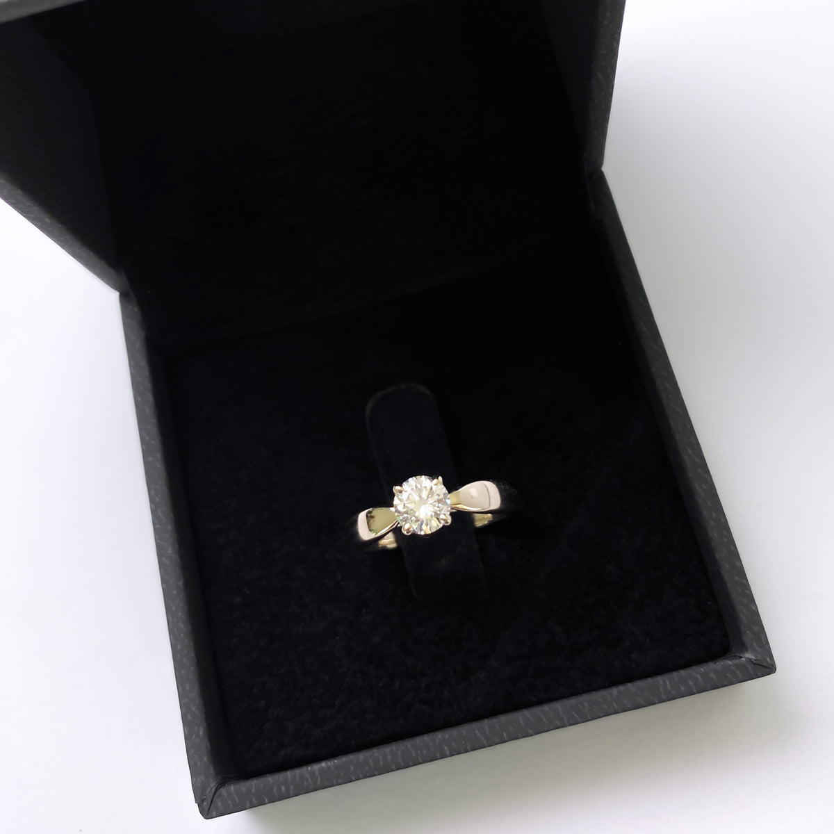 White gold cathedral solitaire engagement ring in a black velvet box