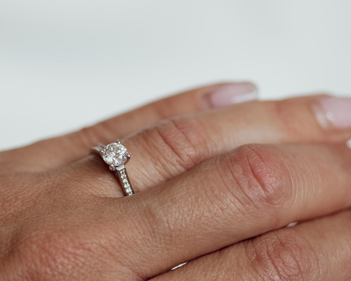 Close-up of a white gold channel-set diamond engagement ring on the hand