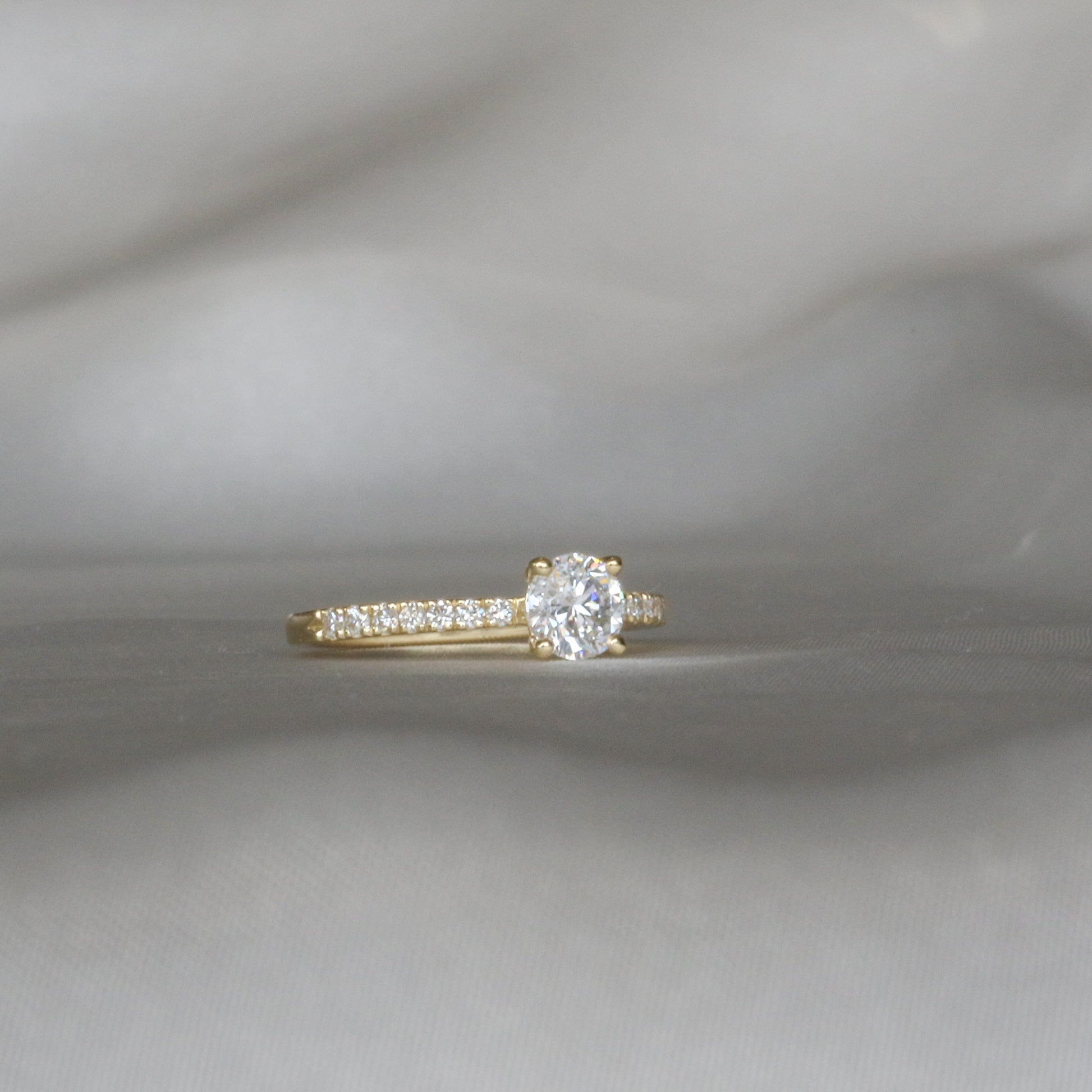 classic diamond ring with diamond pave on white gray background