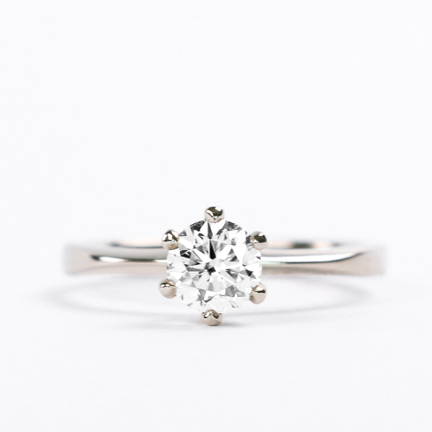 A close-up image of a classic six prong solitaire diamond engagement ring with a 14K yellow gold band.