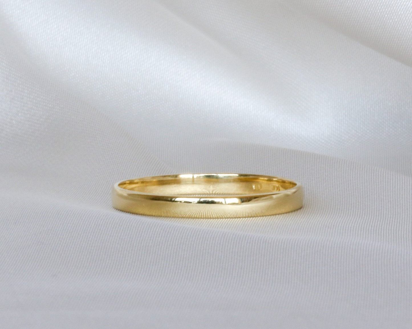 Gold ring on a white fabric background