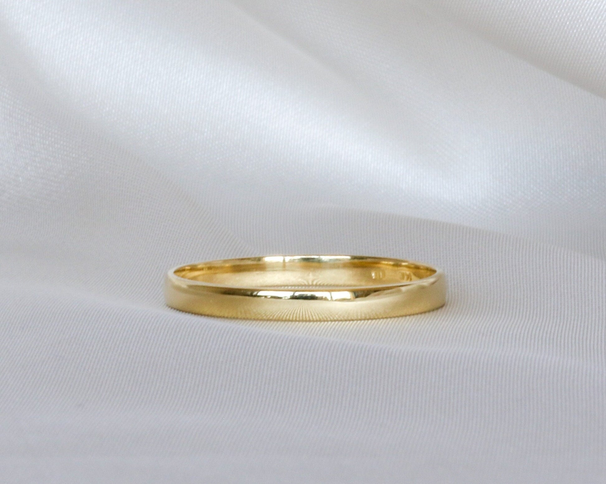 Gold ring on a white fabric background