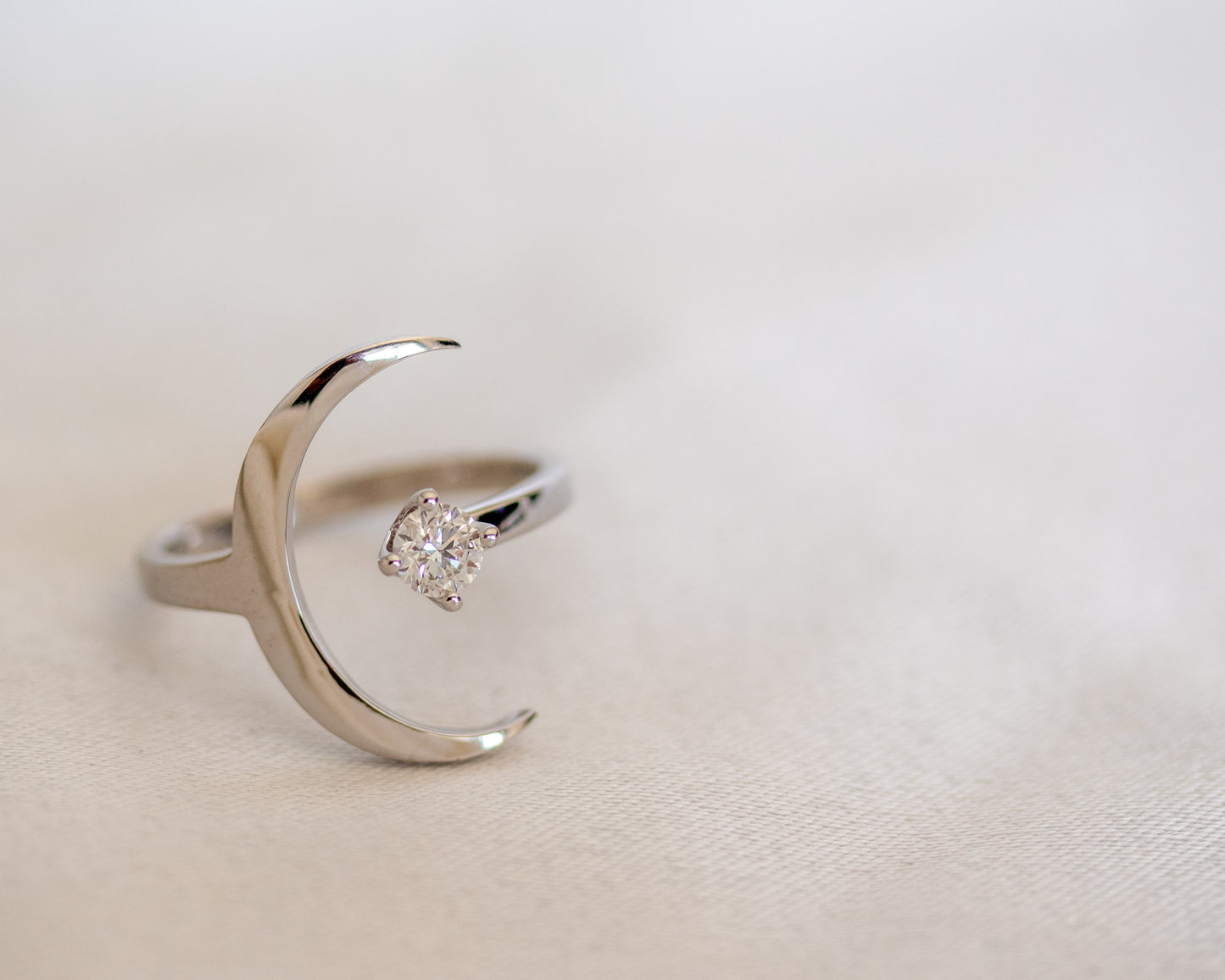 Crescent moon ring with a round diamond in solid gold