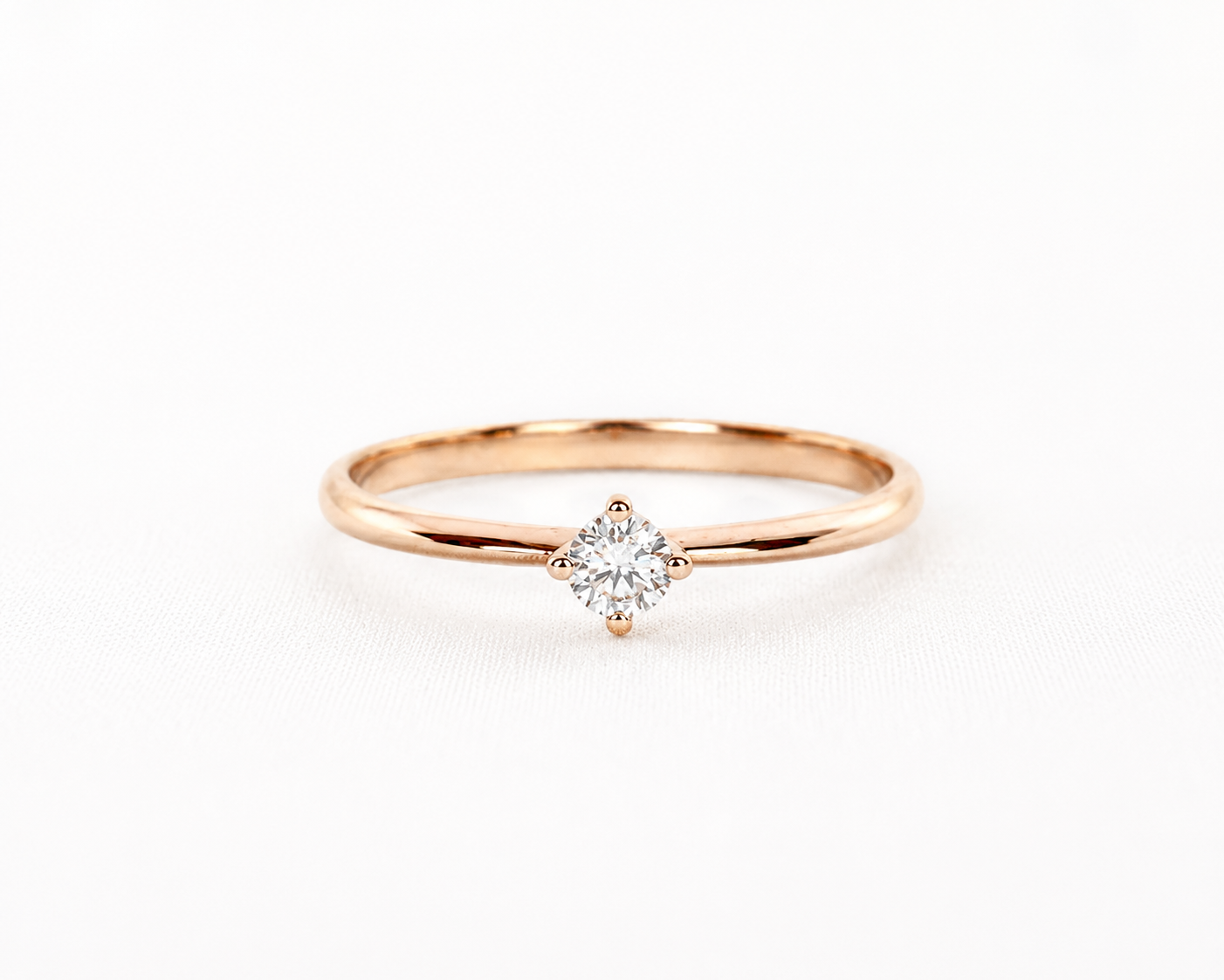 Rose gold ring with a diamond on a light gray background