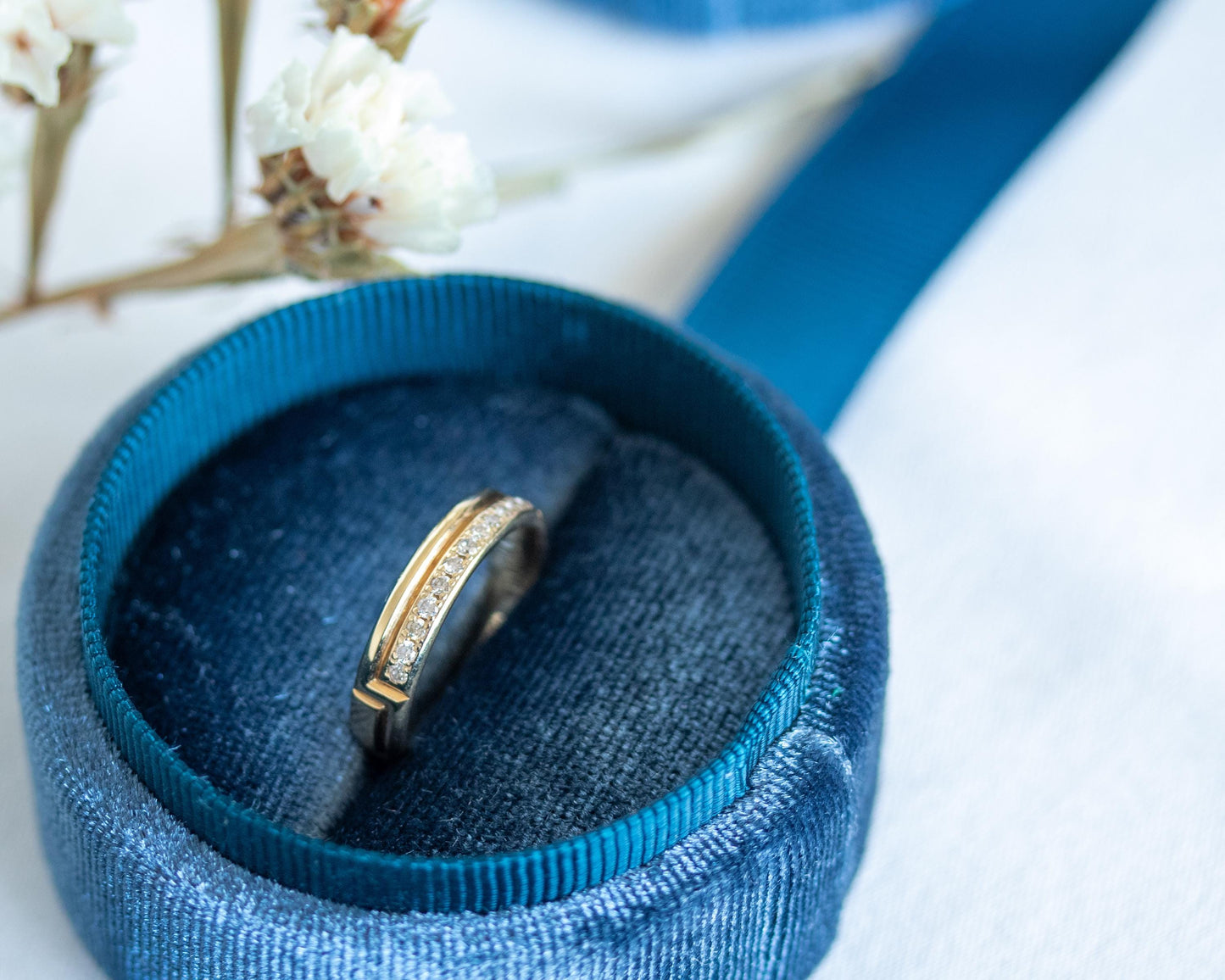 diamond gold ring in blue velvet box with flowers