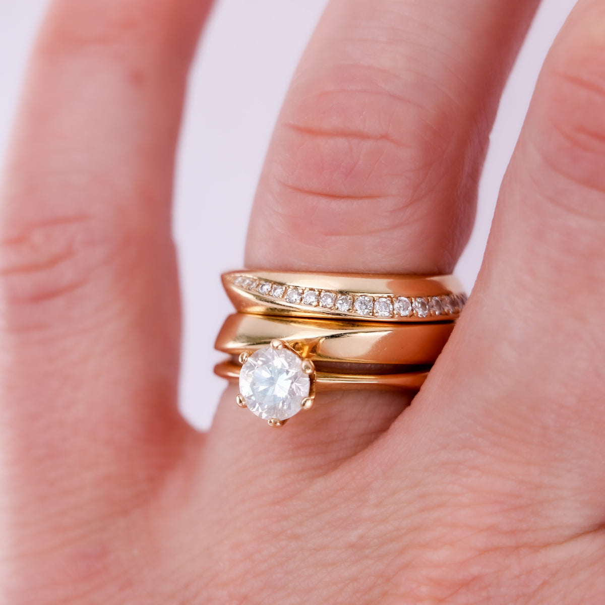 Twisted diamond pavé band and gold band stacked with a round diamond solitaire