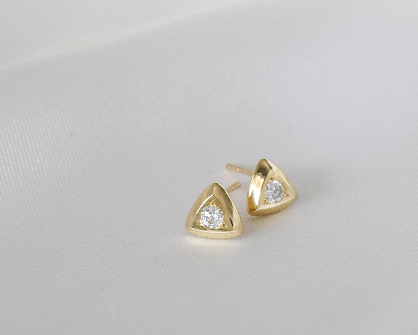 Diamond triangle stud earrings in solid 14K gold, close-up