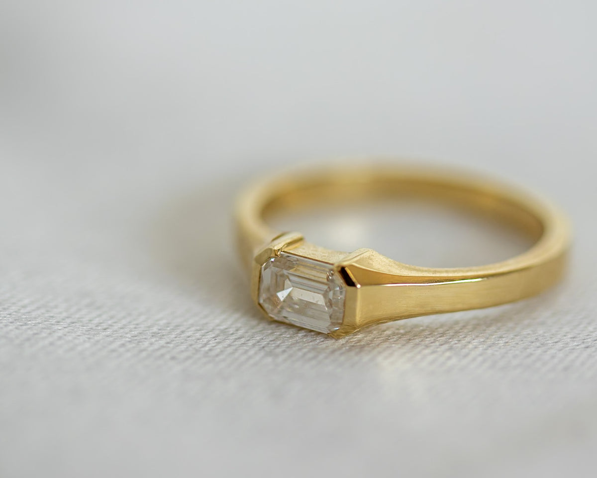 Emerald cut diamond in a half bezel, 14K yellow gold signet-inspired pinky ring