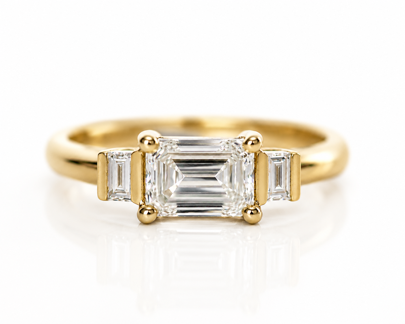 Emerald cut diamond trilogy ring in 14K yellow gold, front view