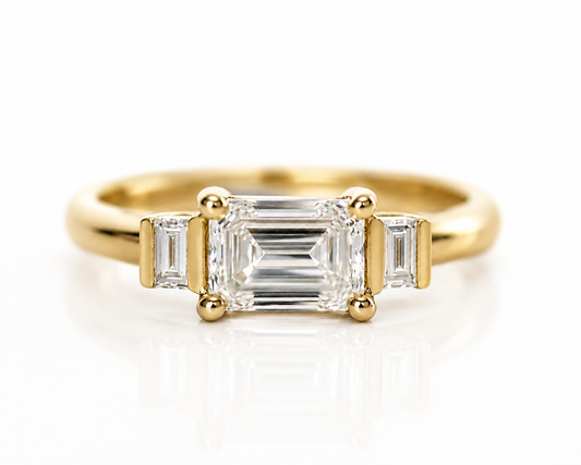Emerald cut diamond trilogy ring in 14K yellow gold, front view