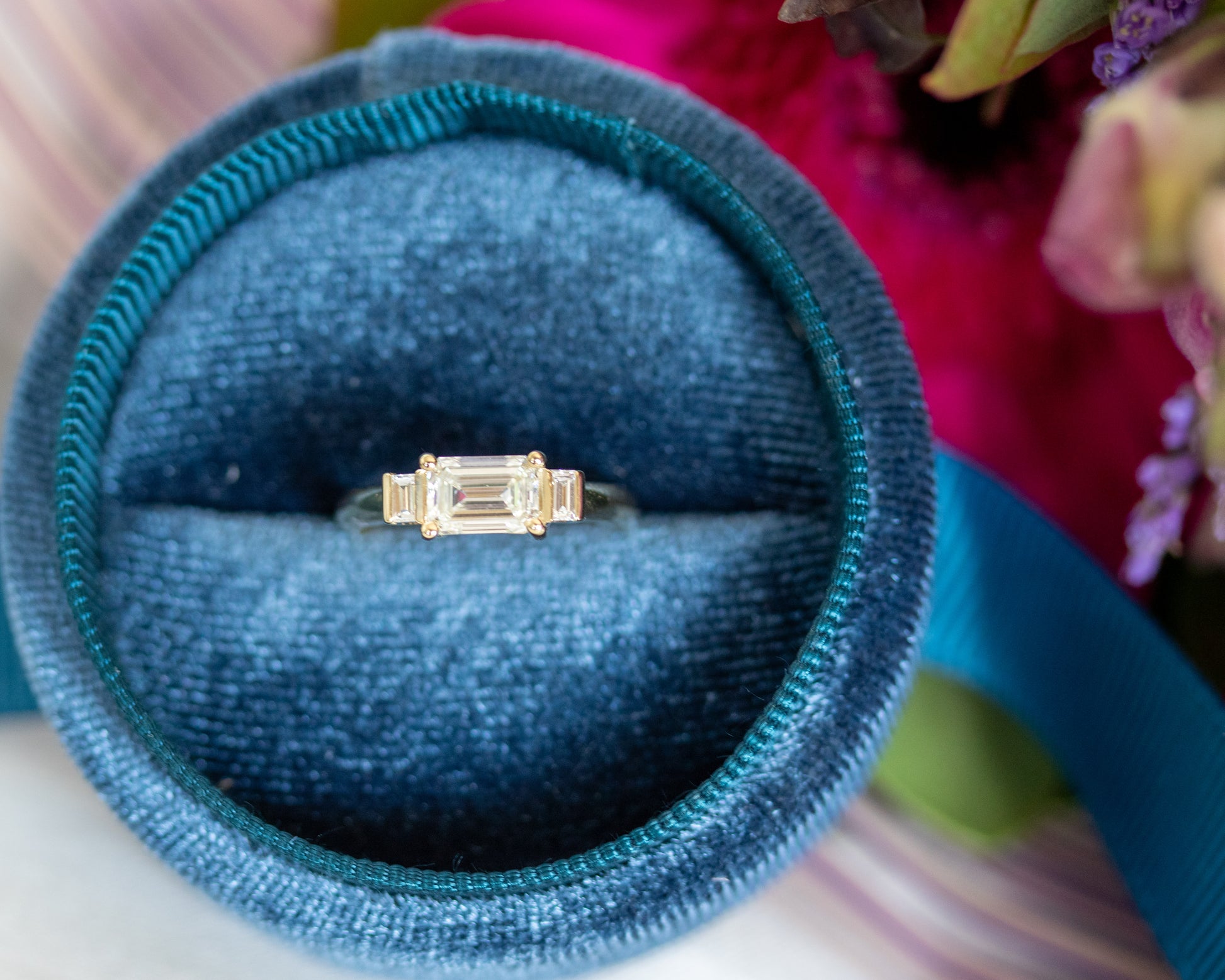 Emerald cut diamond trilogy ring in blue velvet ring box