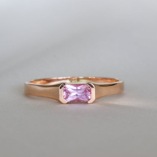 Emerald cut pink sapphire in a half bezel, 14K rose gold ring