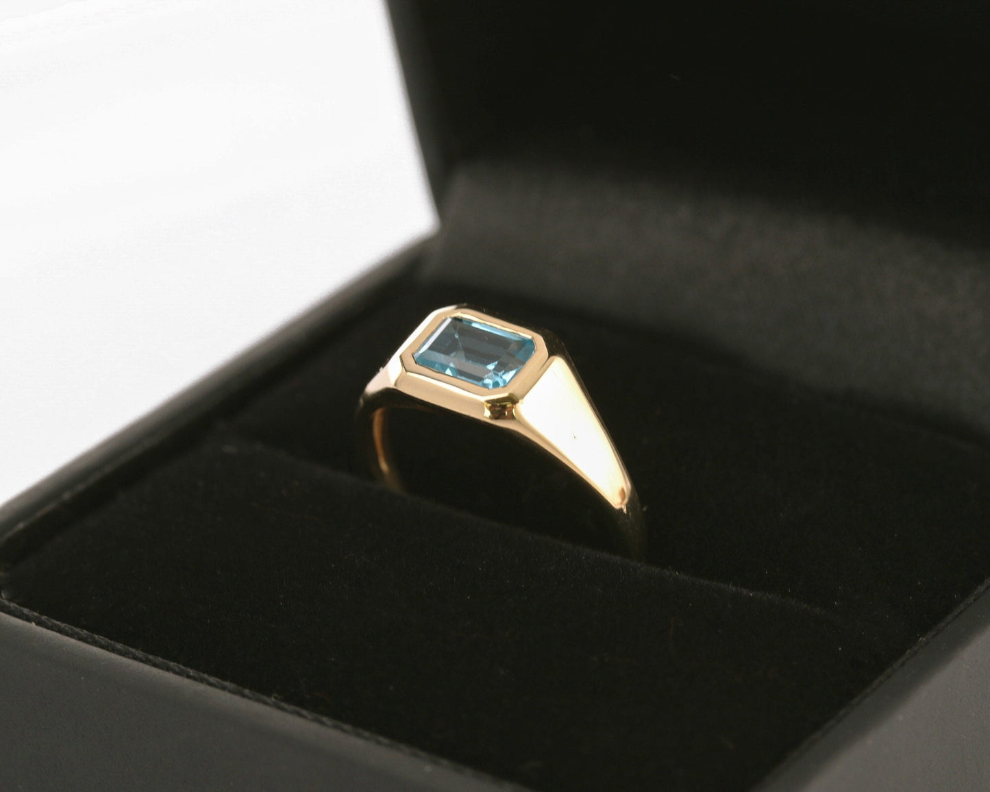 Emerald-cut diamond signet ring in a black gift box