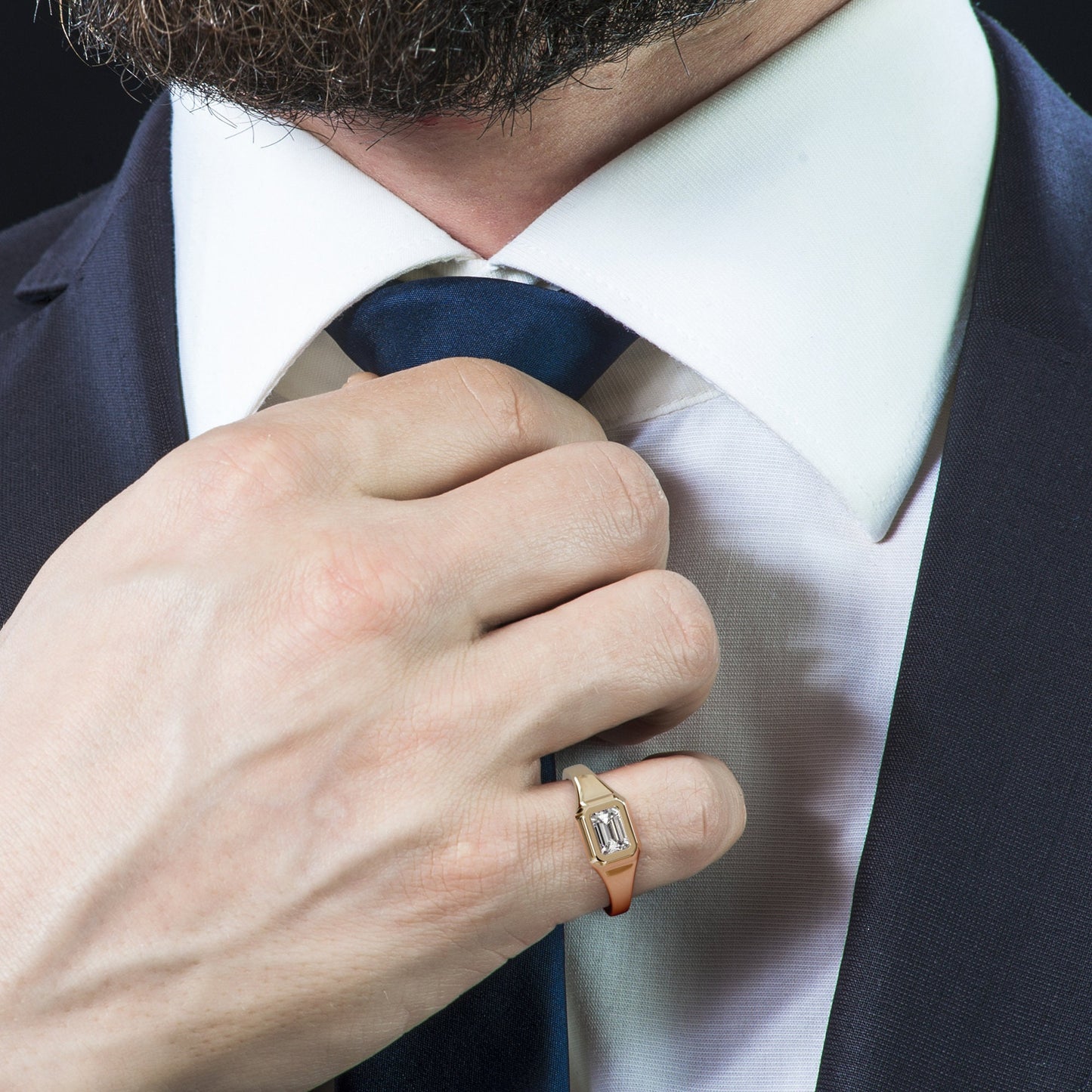 Man in a suit wearing a gold emerald-cut signet ring