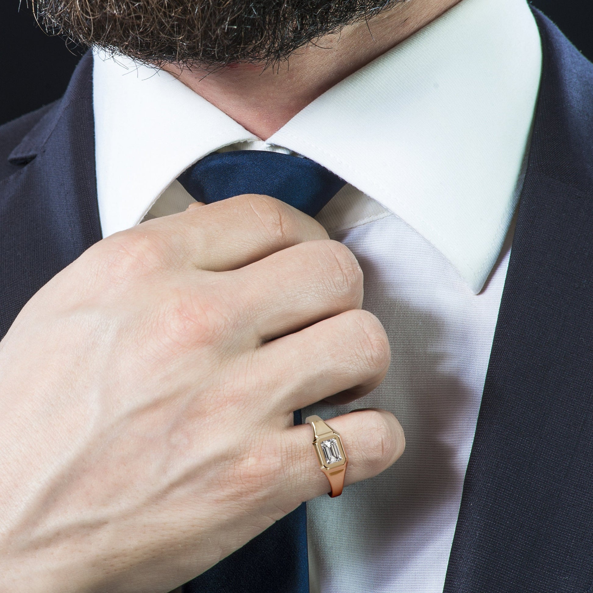 Man in a suit wearing a gold emerald-cut signet ring