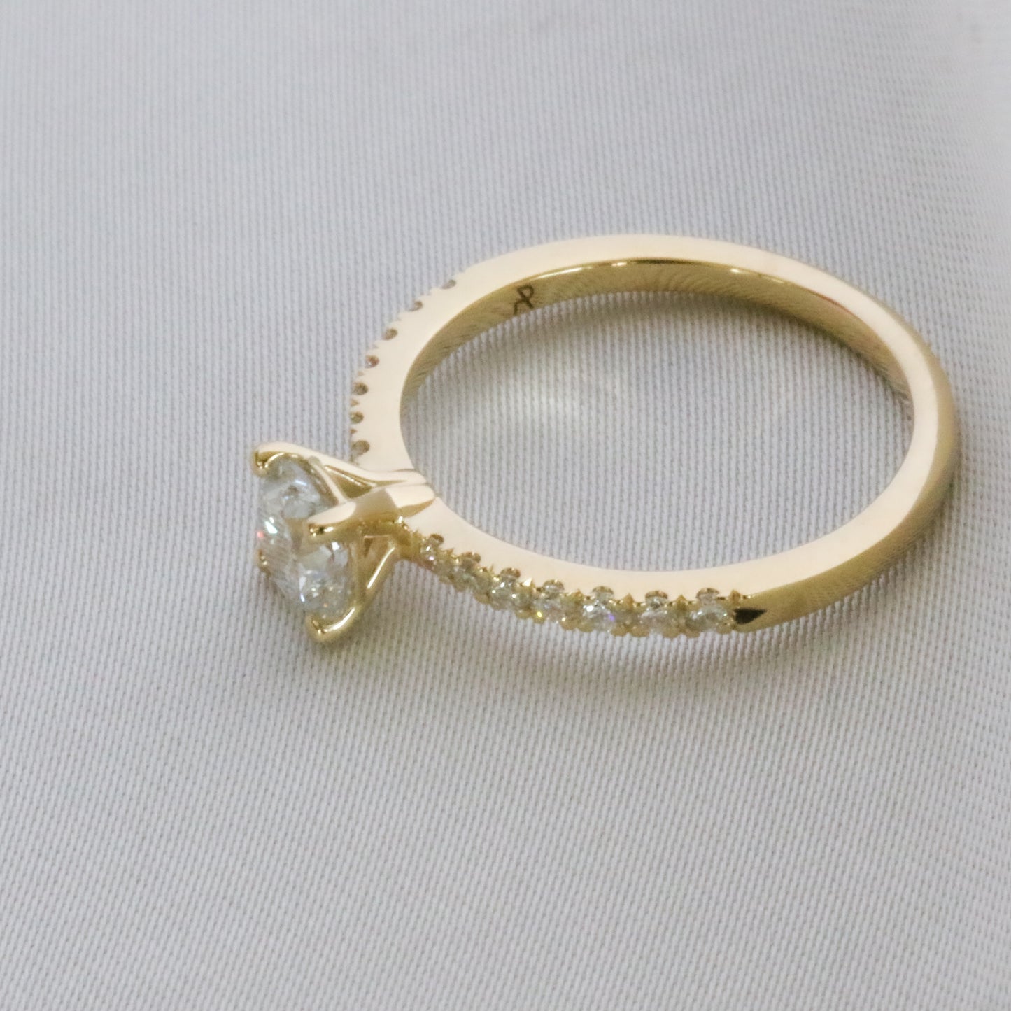 top side view of diamond ring in 14K gold embellished diamonds in pave setting on gray background