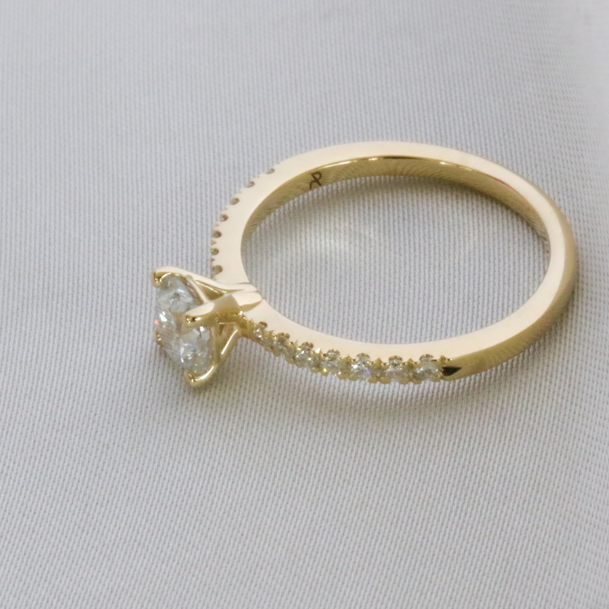 top side view of diamond ring in 14K gold embellished diamonds in pave setting on gray background