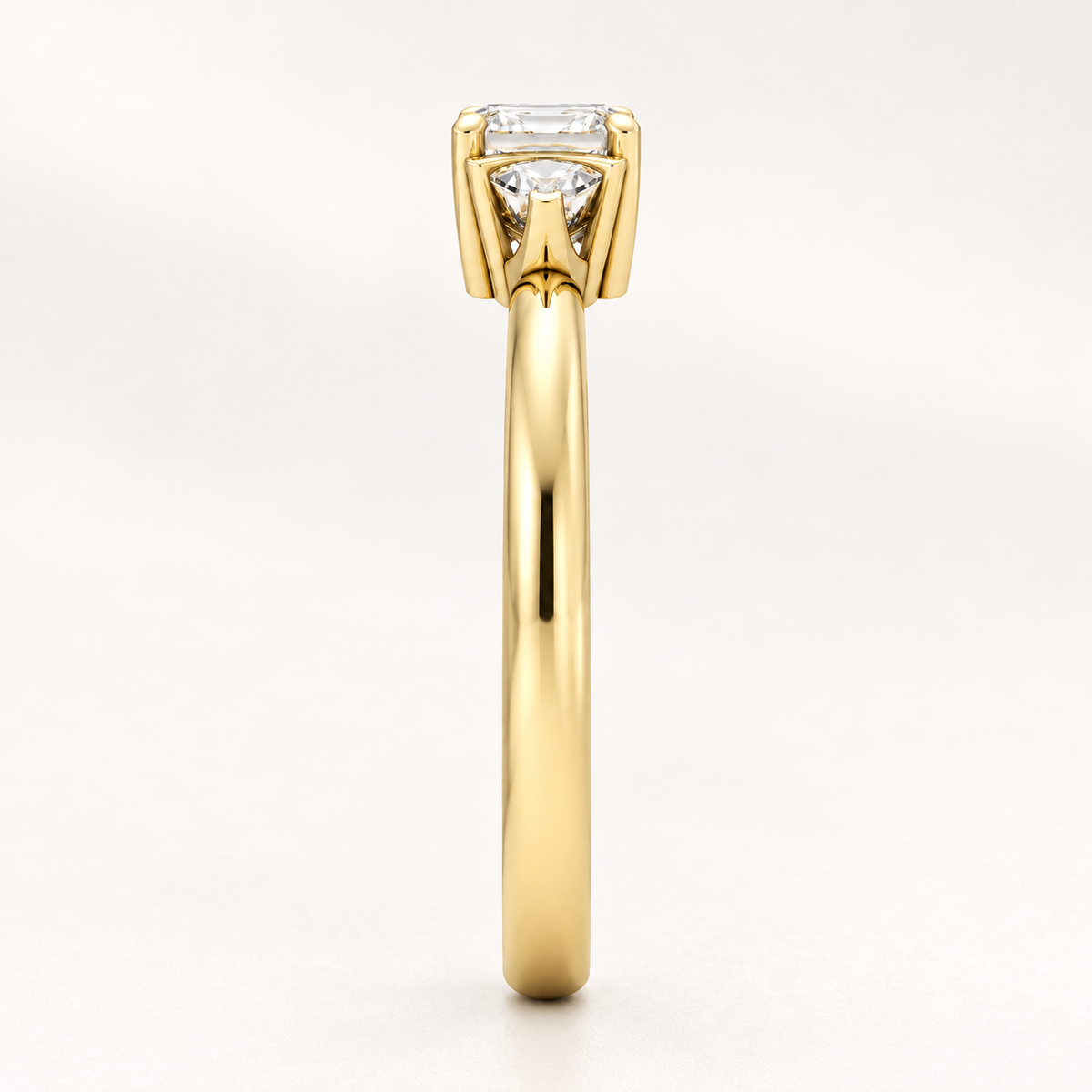 Side profile view of a three-stone diamond engagement ring band in yellow gold