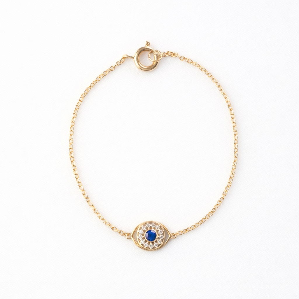 14K yellow gold evil eye bracelet with a blue sapphire and diamond halo on a fine rolo chain, white background