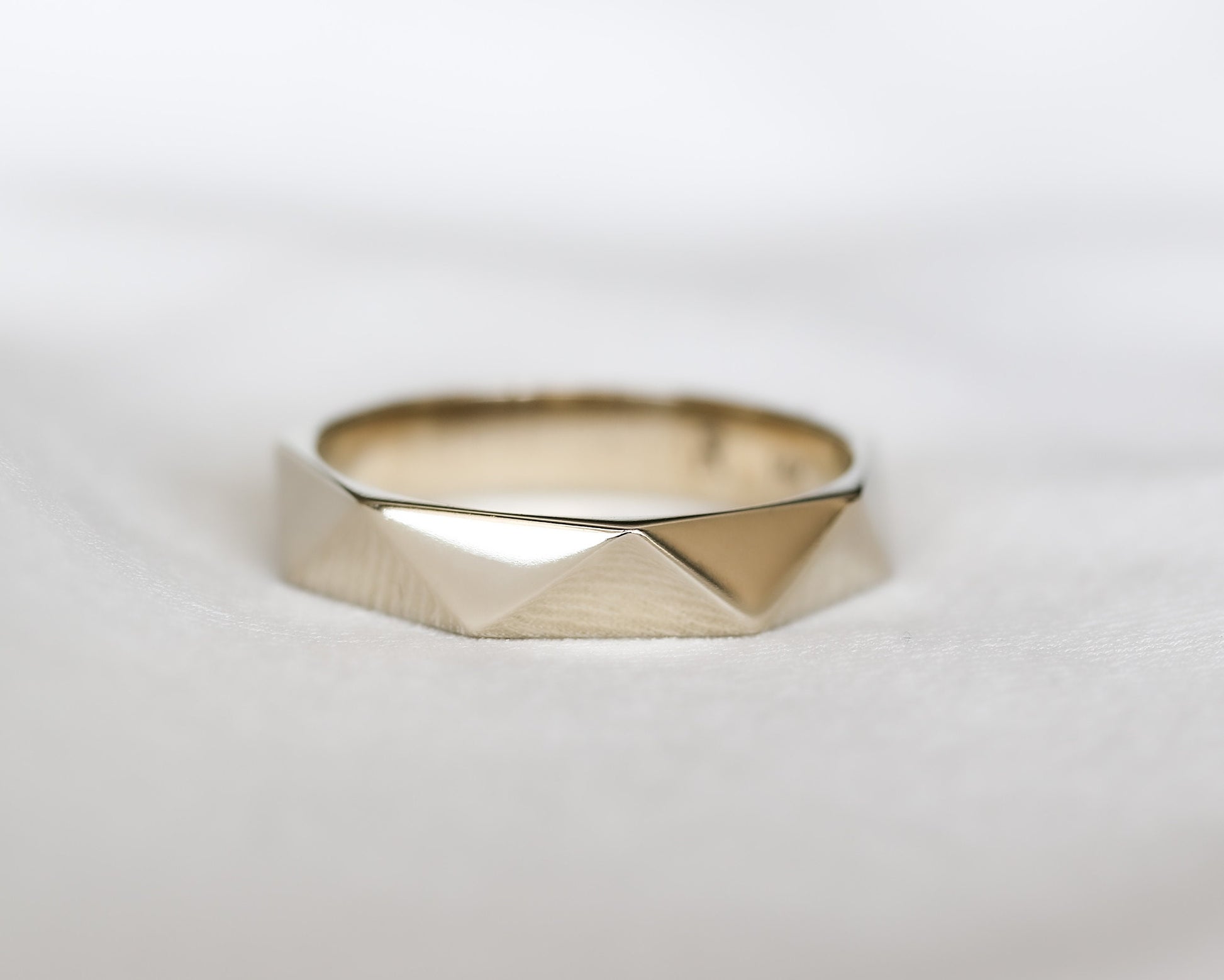 close up faceted triangle gold ring facet detail