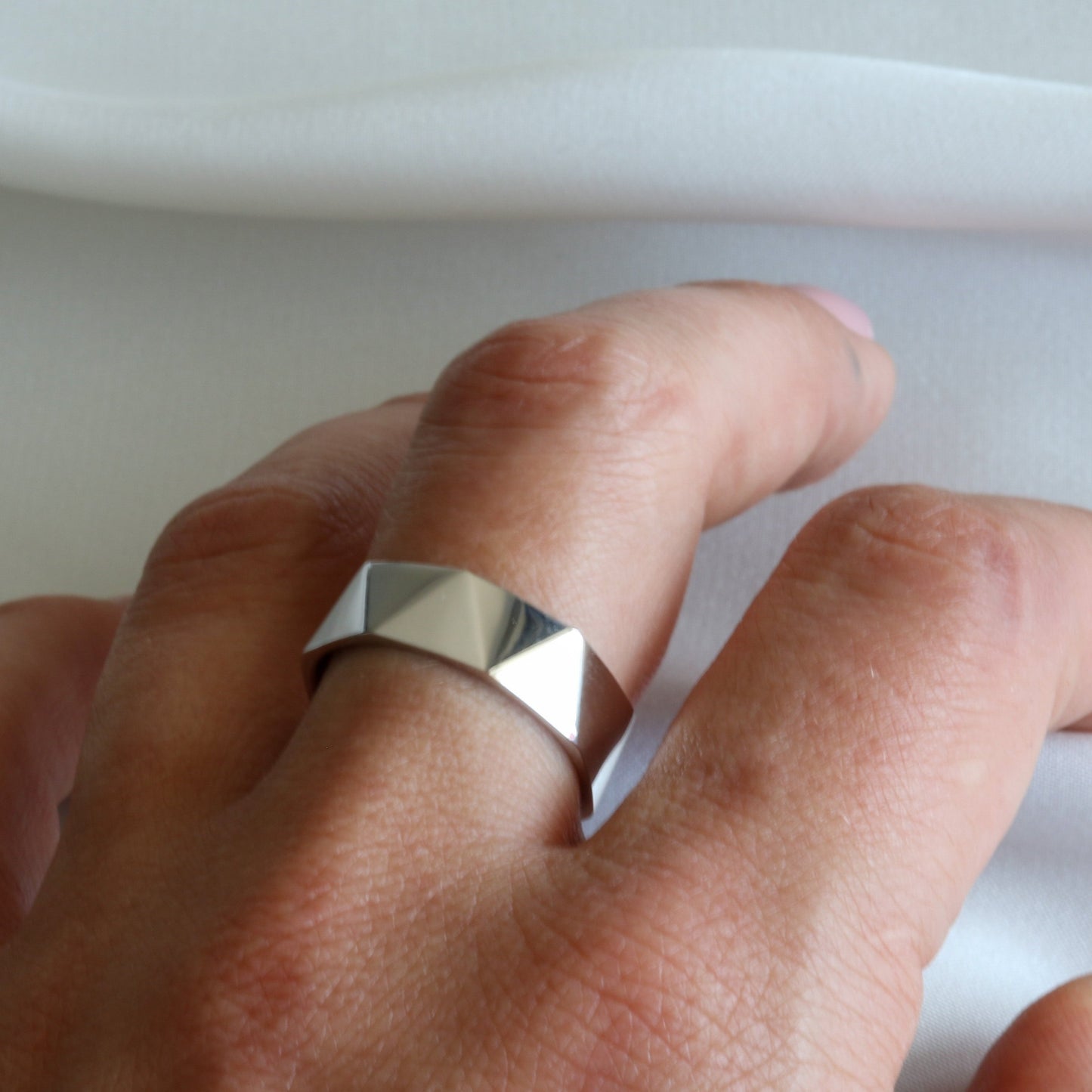 faceted white gold ring on hand