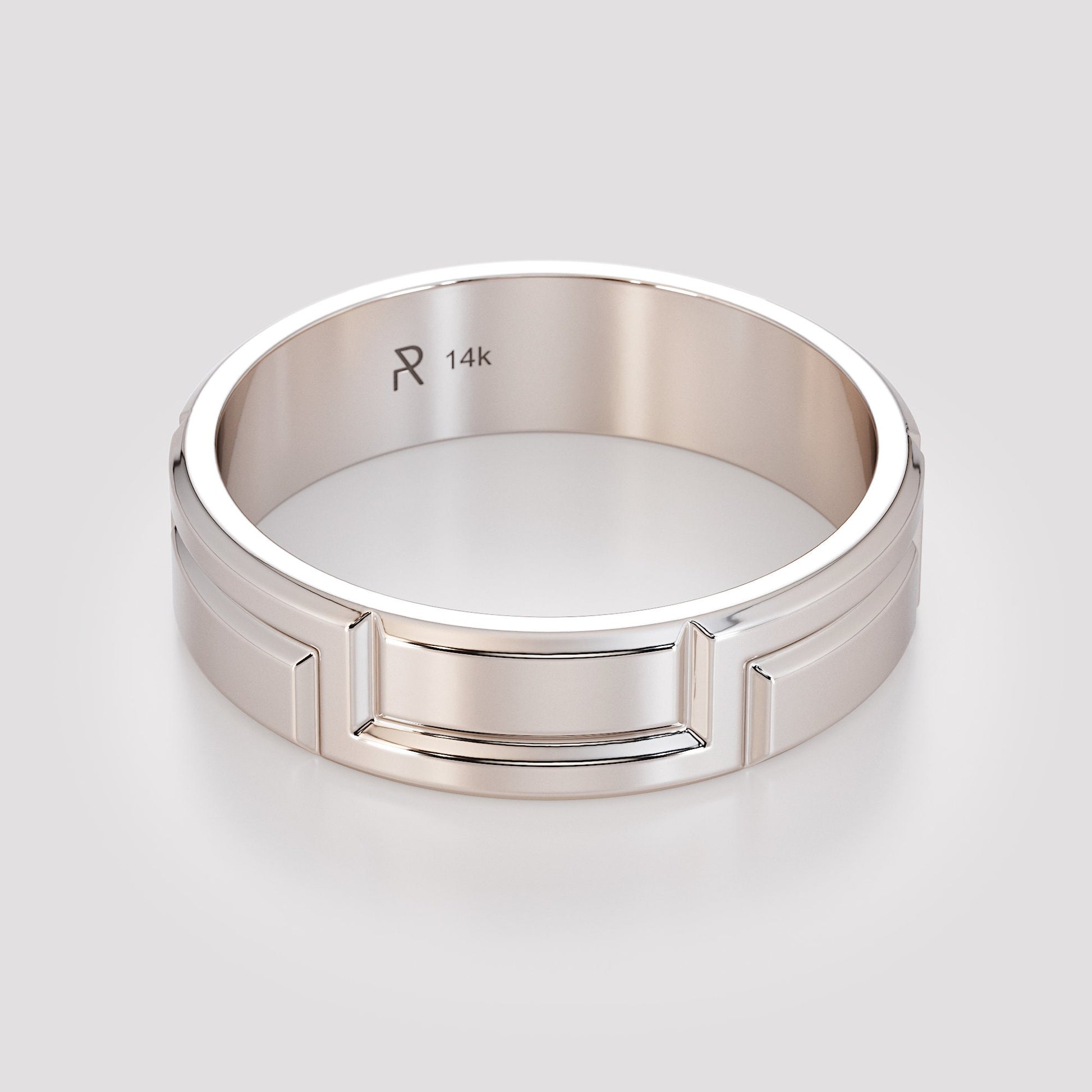fingers holding carved gold ring edge view