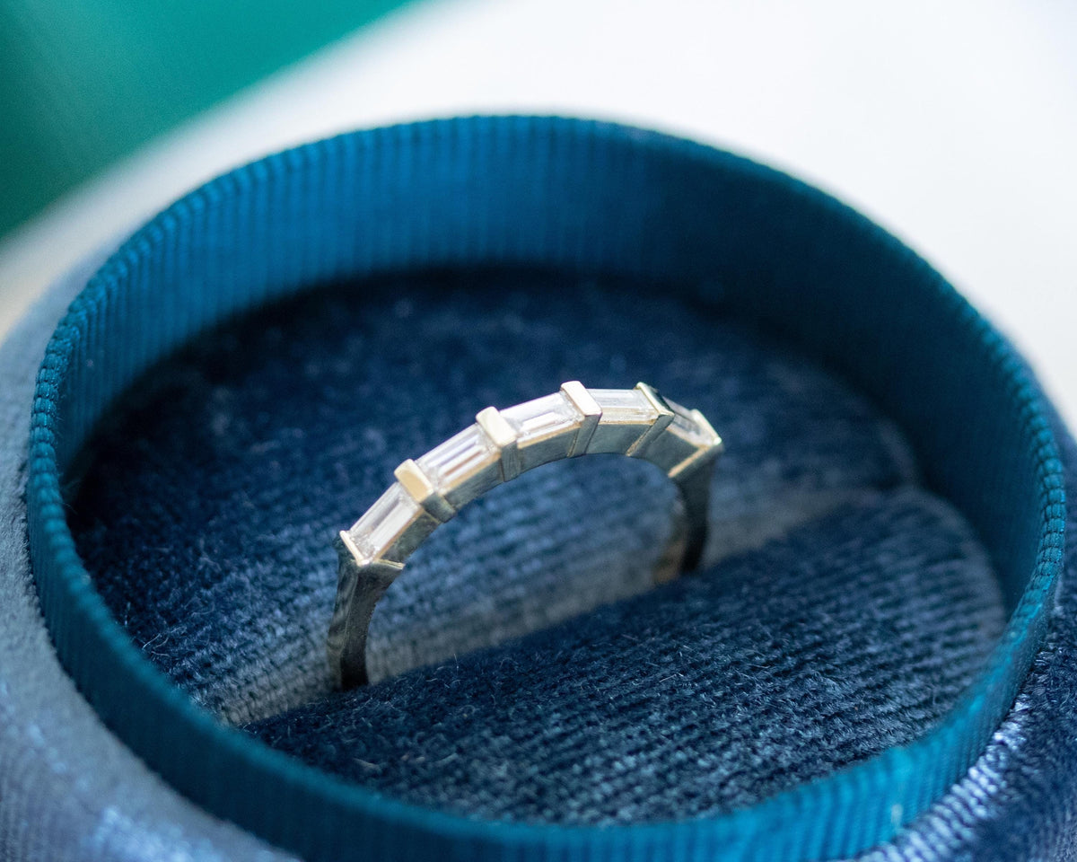 East-west baguette diamond ring in 14K yellow gold, bar-set stones, in a blue velvet ring box