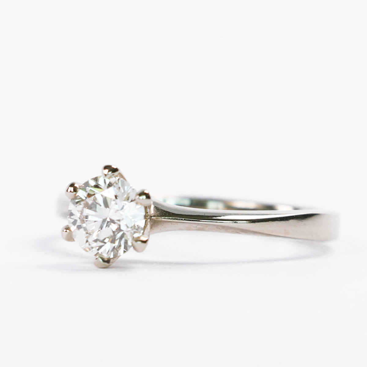 Six-prong round diamond solitaire engagement ring on a white background