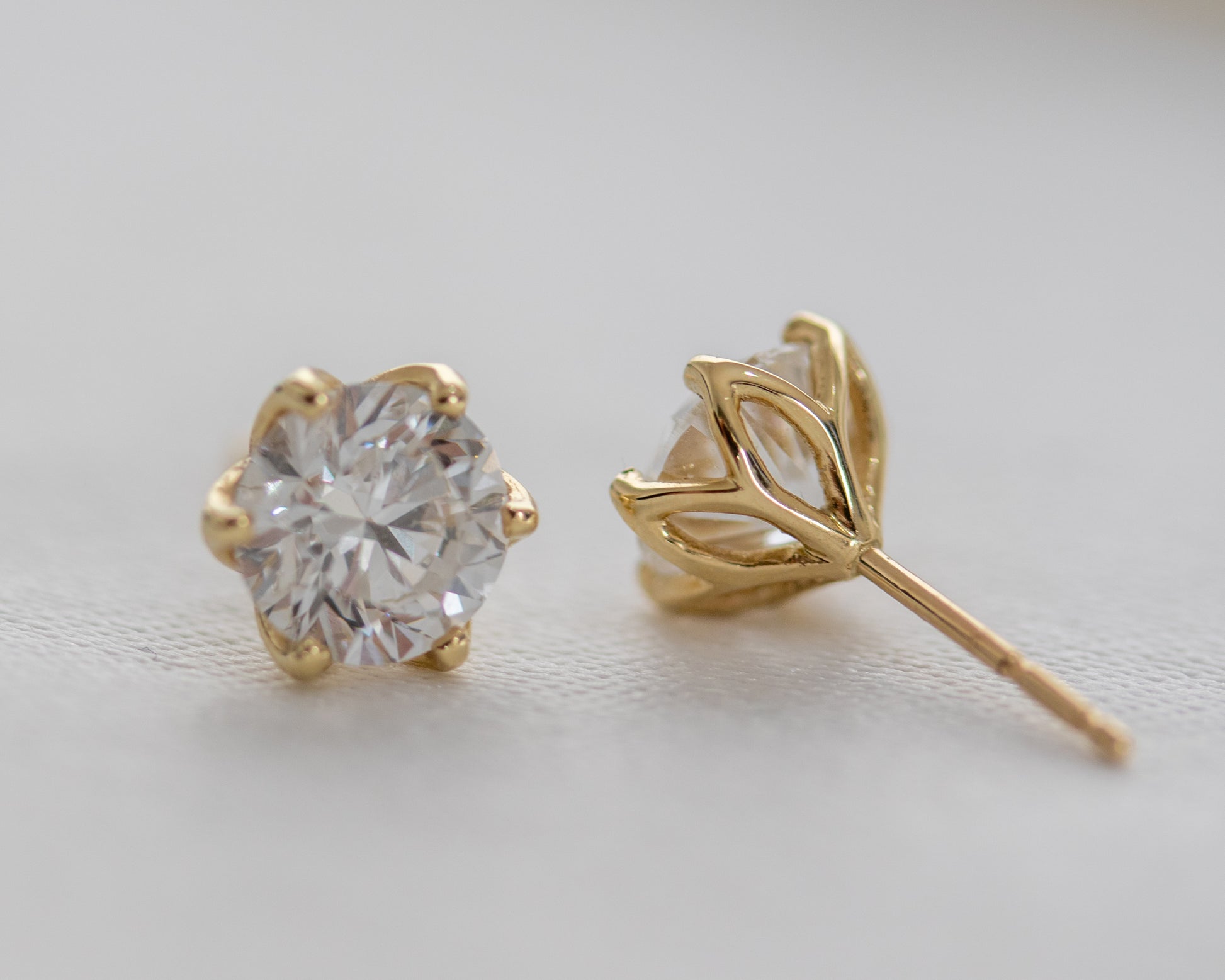 Diamond stud earring with a floral-inspired gold basket, side profile