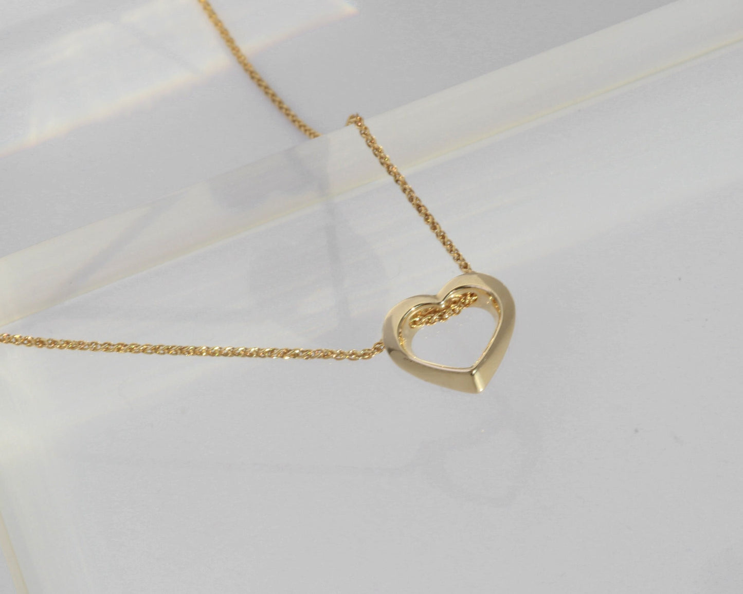 Gold heart-shaped necklace on a light background