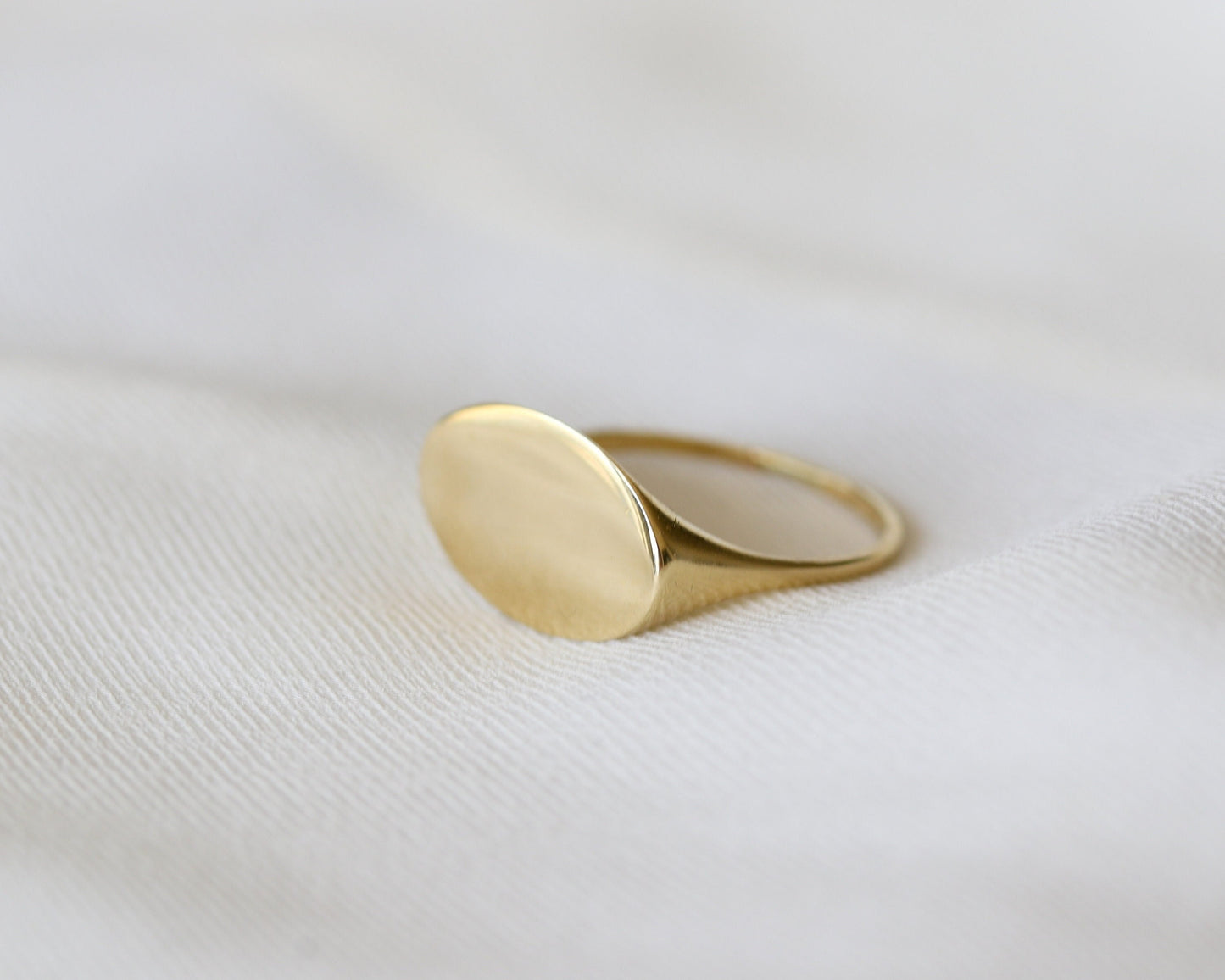 Gold ring on a white fabric background