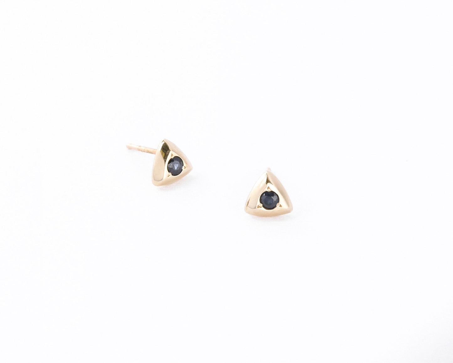 Gold triangle stud earrings with deep blue sapphires